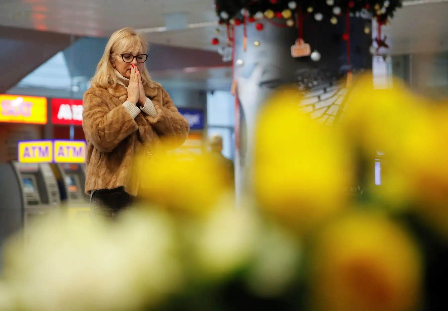 La gente reacciona mientras rinden homenaje cerca de los retratos de los miembros de la tripulación del vuelo PS752 de Ukraine International Airlines en el aeropuerto internacional de Boryspil en Kiev, Ucrania.