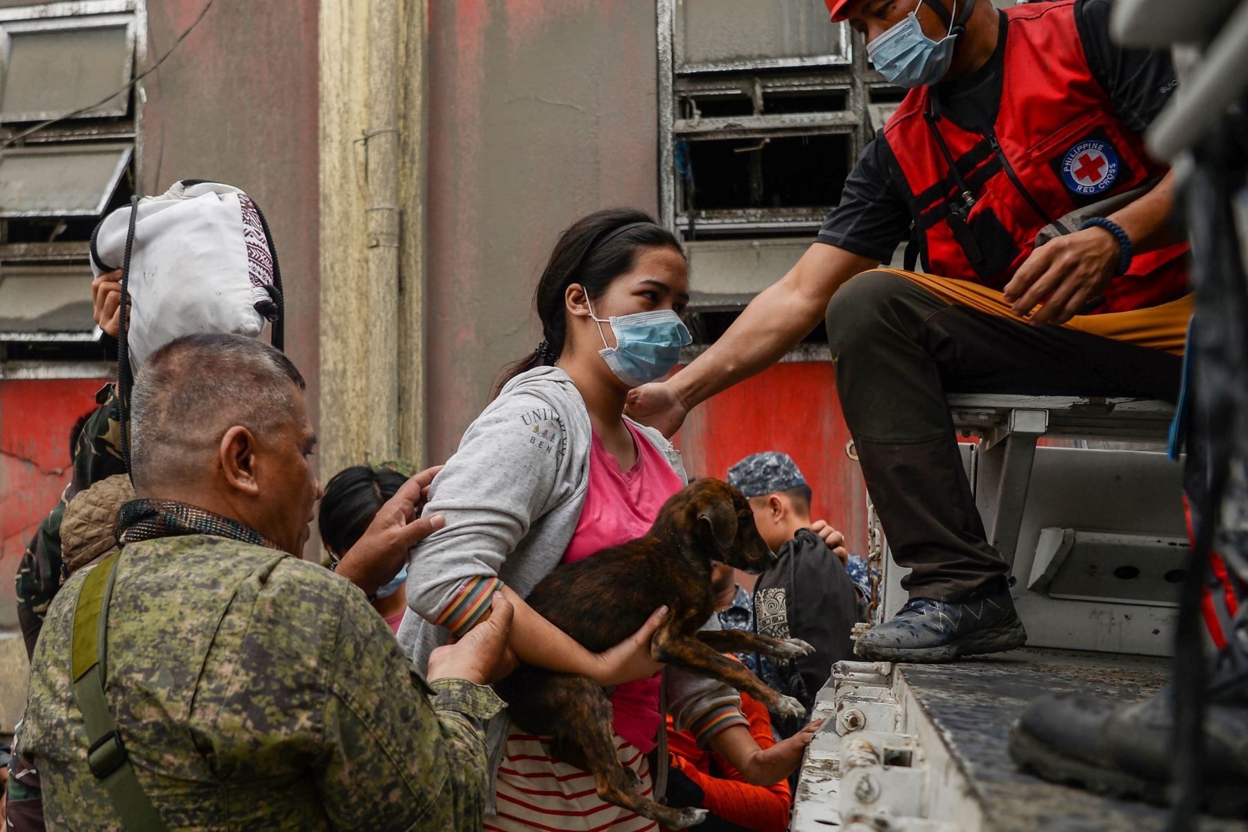 Socorristas ayudan a residentes a subir a un camión mientras evacuan a un área segura en la ciudad de Talisay, provincia de Batangas, al sur de Manila. Foto: AFP