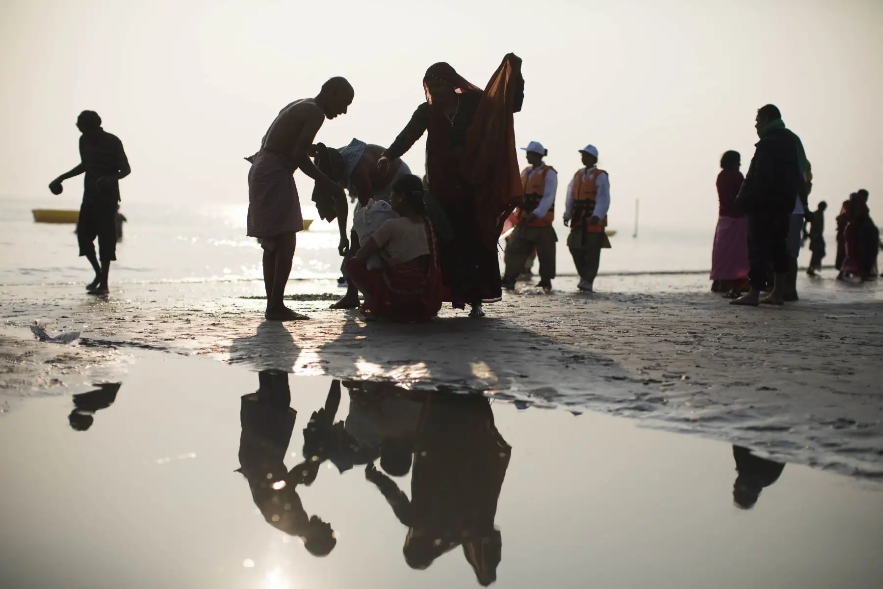 Devotos hindúes se visten después de darse un baño sagrado en la Bahía de Bengala durante el Gangasagar Mela. Foto: AFP