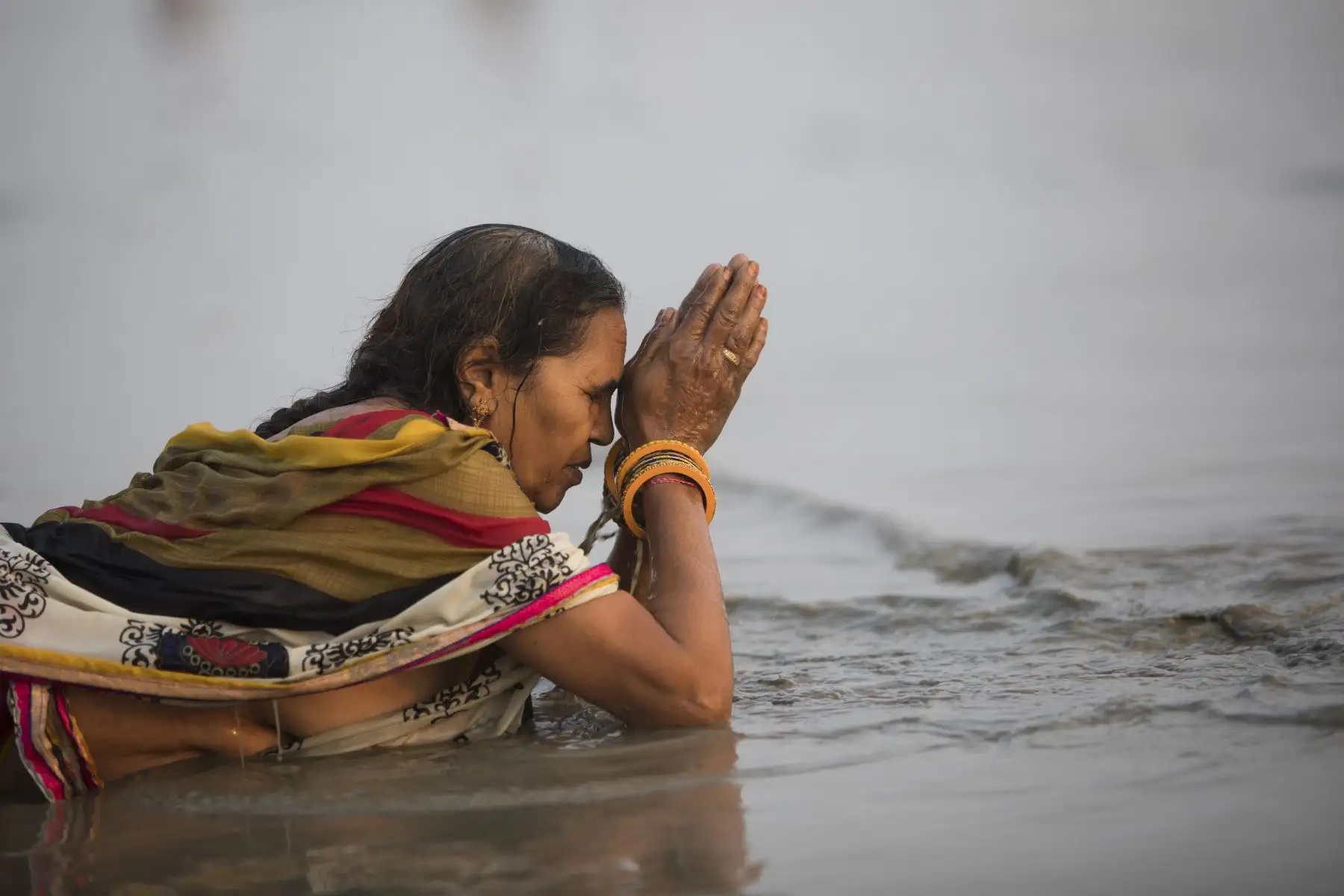 Un devoto hindú realiza un ritual antes de darse un baño sagrado en la Bahía de Bengala durante el Gangasagar Mela. Foto: AFP