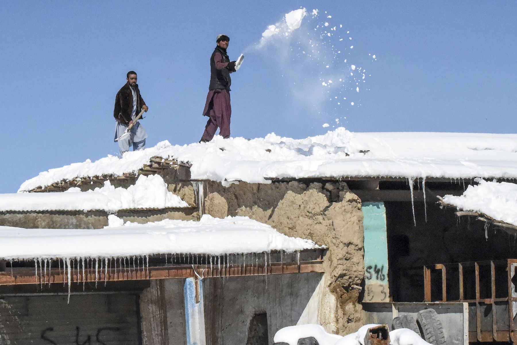 Trabajadores retiran la nieve del techo de un hotel después de fuertes nevadas en el área de Khanozai, a unos 75 kilómetros al noreste de la capital de la provincia de Quetta. Foto: AFP