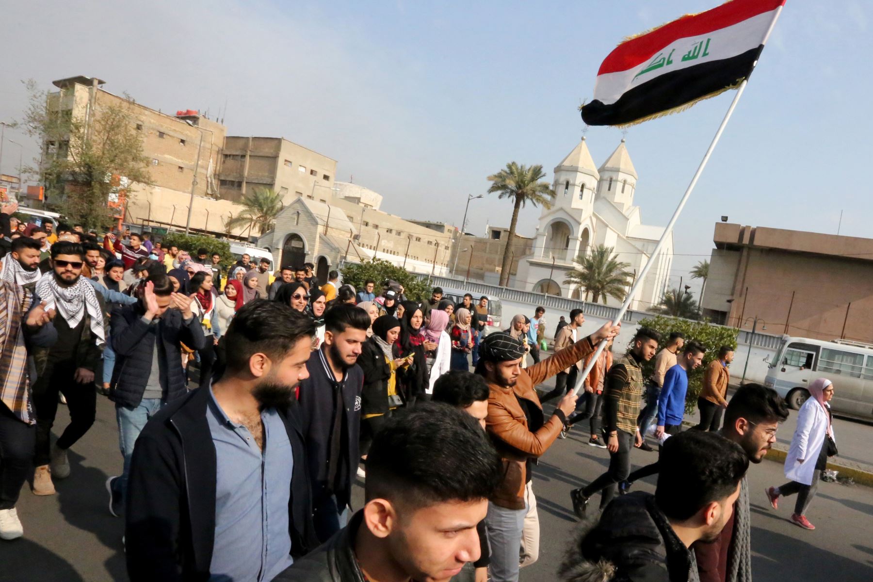 Los manifestantes iraquíes antigubernamentales marchan con banderas nacionales mientras se reúnen para protestar en la plaza Tayaran, cerca de la plaza Tahrir en el centro de la capital, Bagdad. Foto: AFP