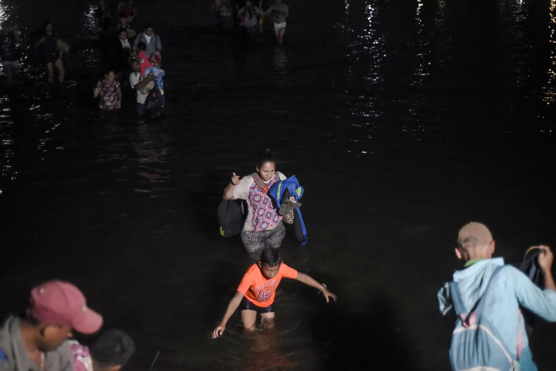 Los migrantes centroamericanos que viajan en caravana a los EE. UU., Cruzan el río Suichate de regreso a Tecun Uman, después de no poder ingresar a Ciudad Hidalgo, México. Foto: AFP