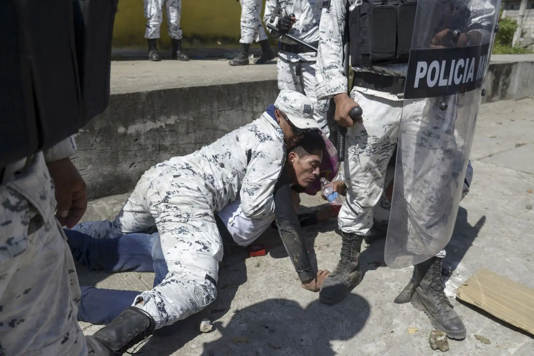 Un miembro de la Guardia Nacional de México detiene a un migrante centroamericano, parte de un grupo de hondureños en su mayoría que viajan en caravana a los EE. UU., Después de cruzar el río Suichate, la frontera natural entre Guatemala y Ciudad Hidalgo, México. AFP