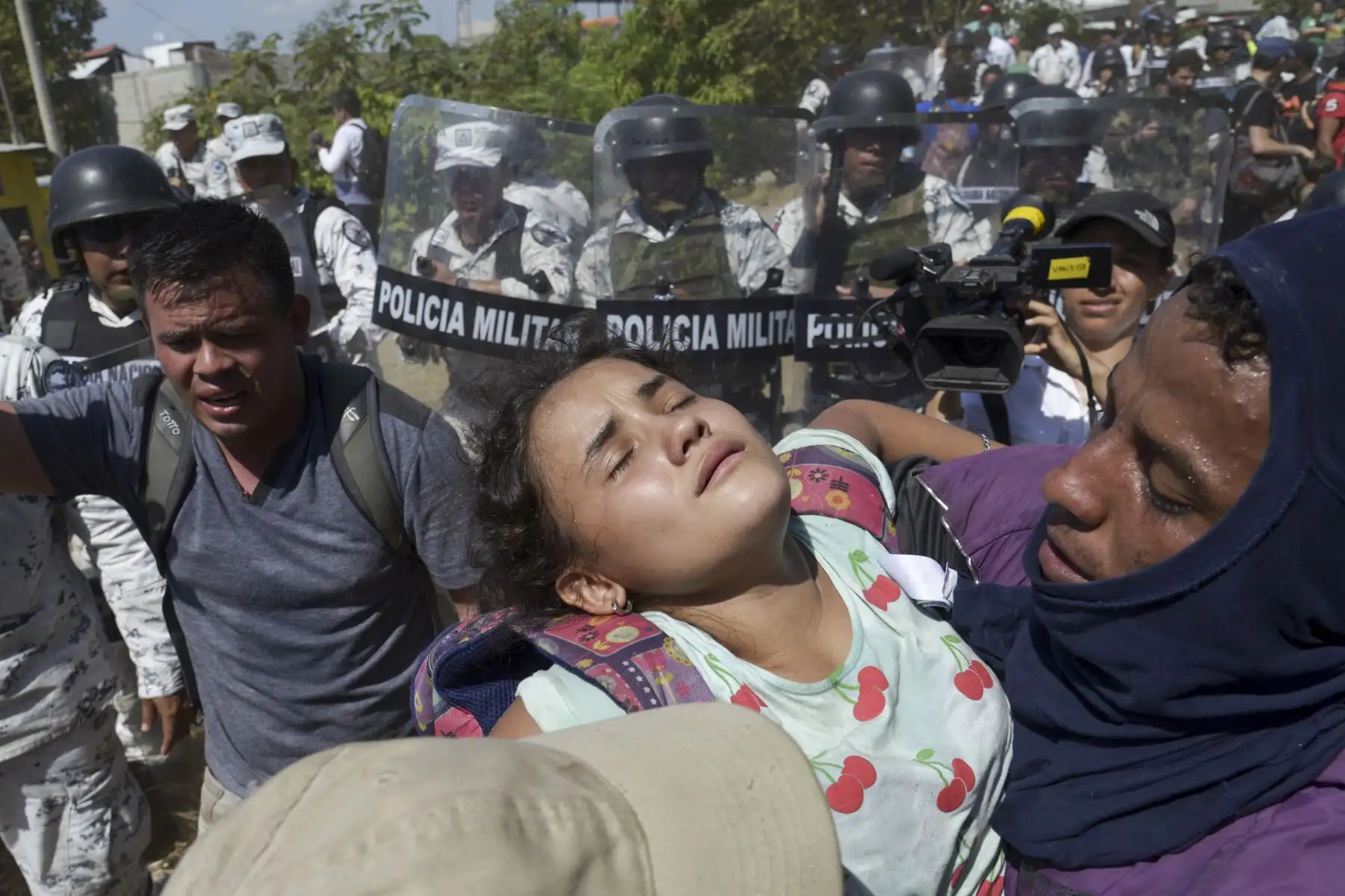 Un migrante centroamericano, lleva a una niña después de que las fuerzas de seguridad mexicanas les impiden cruzar ilegalmente a México en Ciudad Hidalgo. AFP