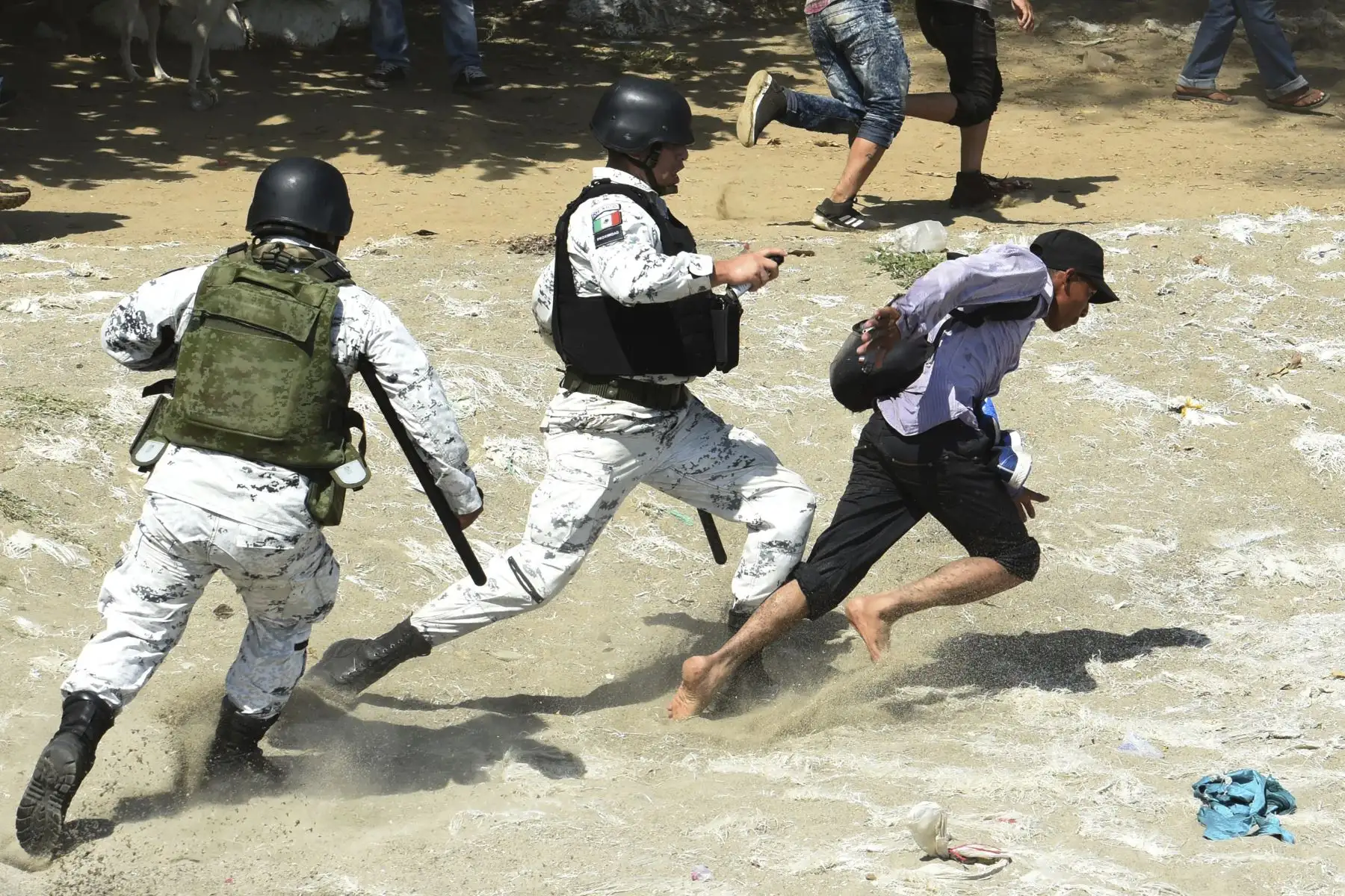 Un miembro de la Guardia Nacional de México aborda a un migrante centroamericano, parte de una caravana  en su mayoría hondureños que viajan en caravana a los EE. UU., Después de cruzar el río Suichate, la frontera natural entre Tecun Uman en Guatemala y Ciudad Hidalgo en México. AFP