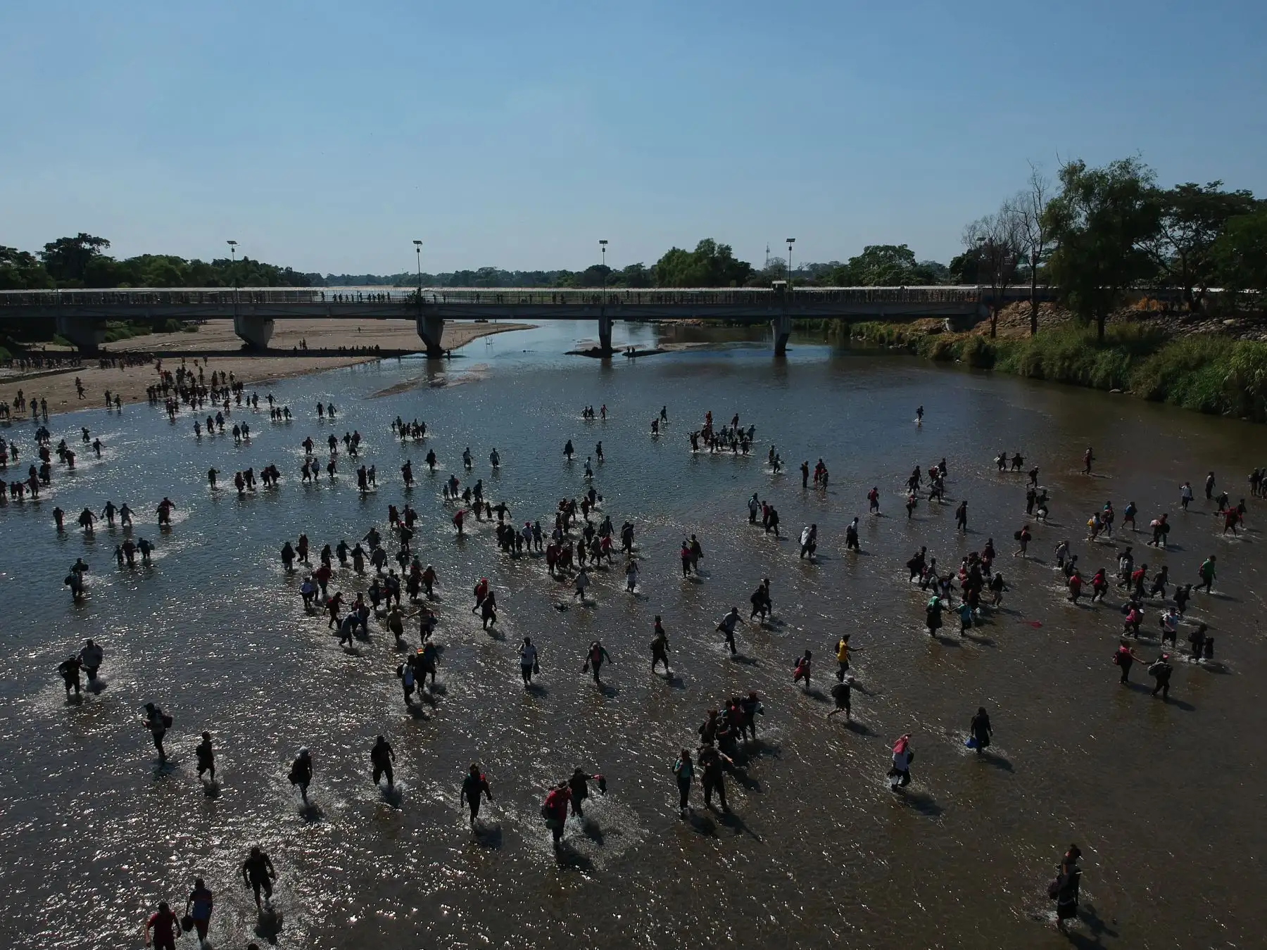 Vista aérea que muestra a los migrantes centroamericanos, en su mayoría hondureños que viajan en caravana a los Estados Unidos, cruzan el río Suichate, la frontera natural entre Tecum Uman, Guatemala y Ciudad Hidalgo, México. AFP