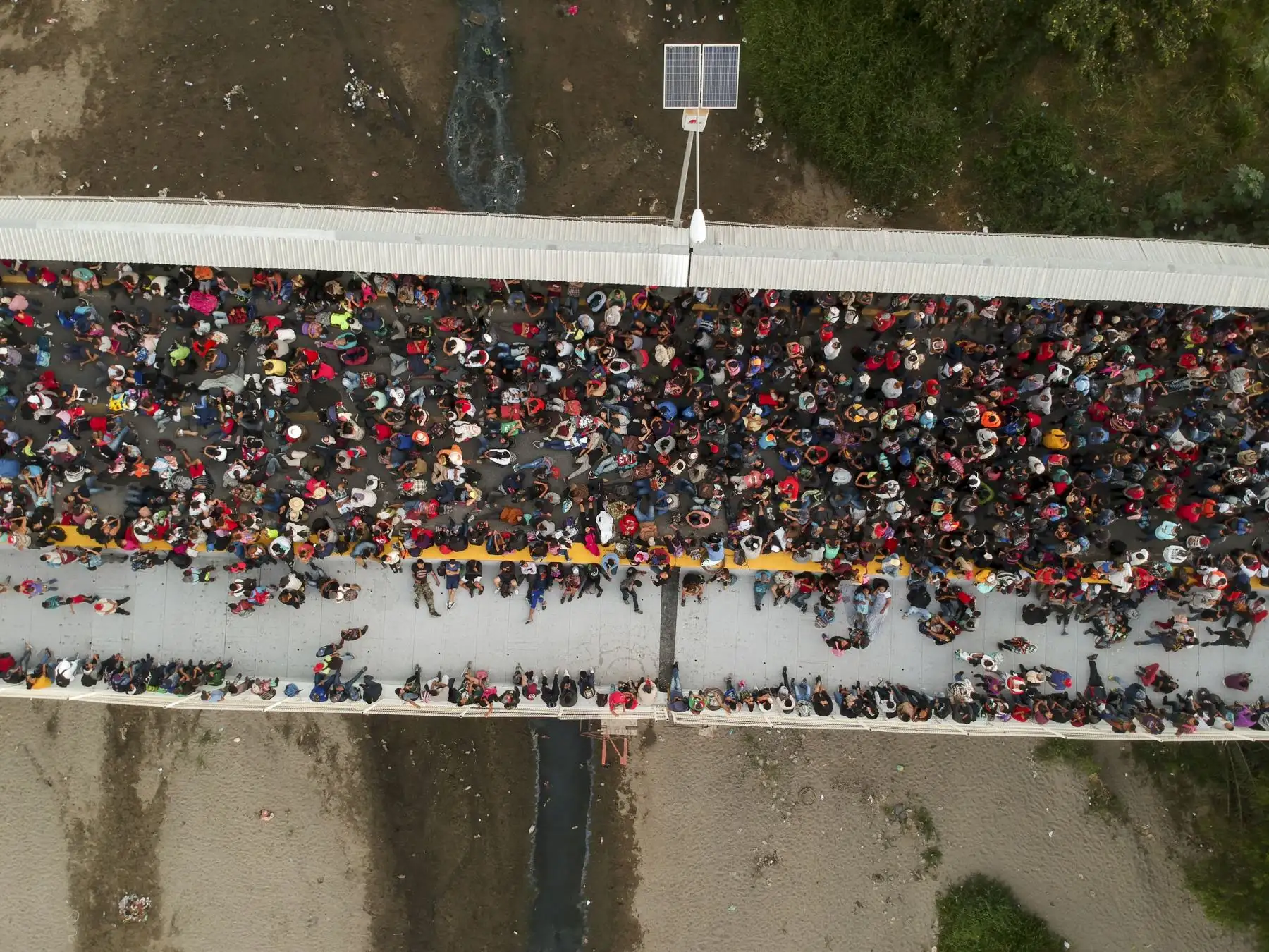 Los migrantes centroamericanos, que viajan en caravana a los EE. UU., Permanecen en el puente internacional que conecta Tecum Uman, Guatemala, con Ciudad Hidalgo, México. AFP