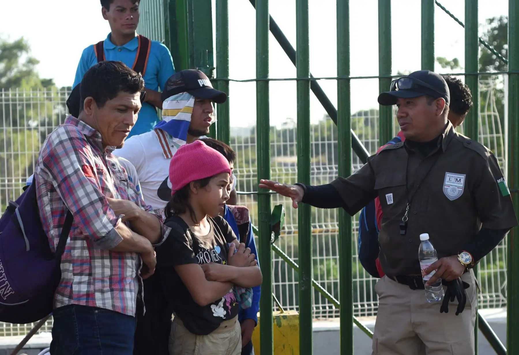 Un oficial de migración mexicano habla con inmigrantes hondureños que esperan para cruzar el puente fronterizo internacional desde Ciudad Tecun Uman en Guatemala hasta Ciudad Hidalgo en México. AFP