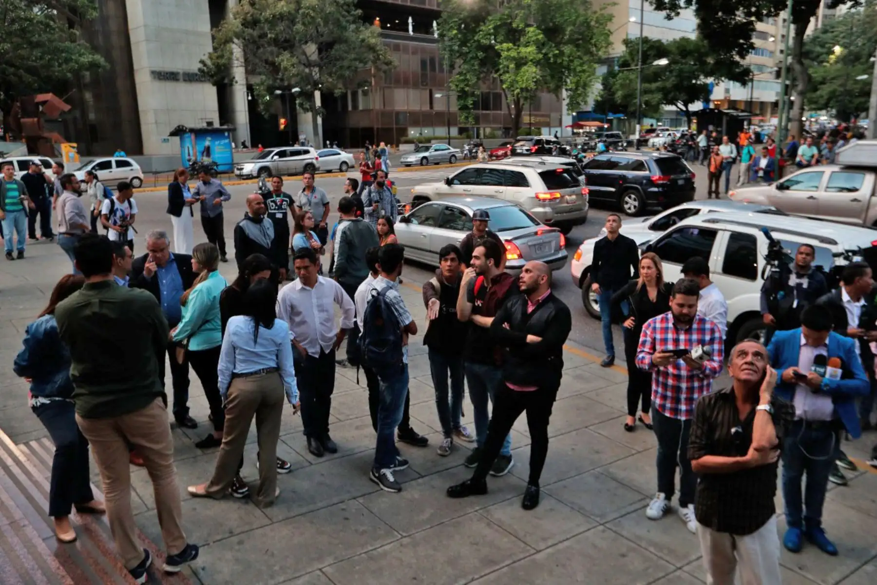 Simpatizantes de Juan Guaidó y diputados venezolanos aguardan en los alrededores del edificio donde fue allanada la oficina del líder opositor. Foto: EFE