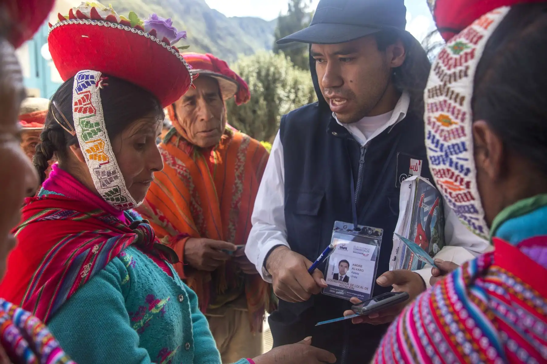 Un empleado de la Oficina Nacional de Preocesos Electorales (ONPE) ayuda a buscar las mesas de votación a integrantes de la comunidad campesina Quelccanqa  del centro poblado de Ollantaytambo en el departamento del Cuzco (Perú), donde se realizaron  elecciones extraordinarias al Congreso.
Foto: EFE