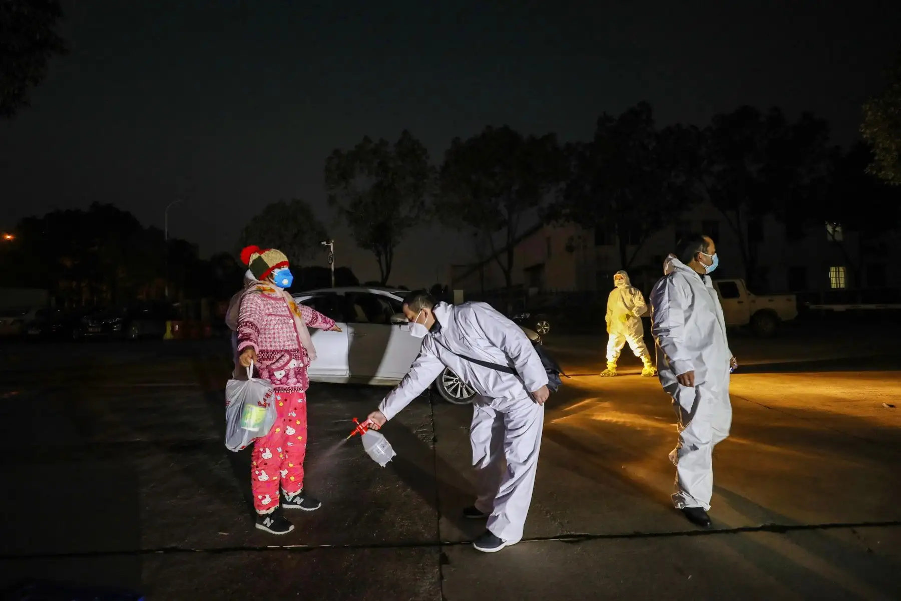 Miembro del personal médico  rociando desinfectante sobre un paciente después de regresar de un hospital y volver a ingresar a una zona de cuarentena en Wuhan, el epicentro del nuevo brote de coronavirus, en China. AFP