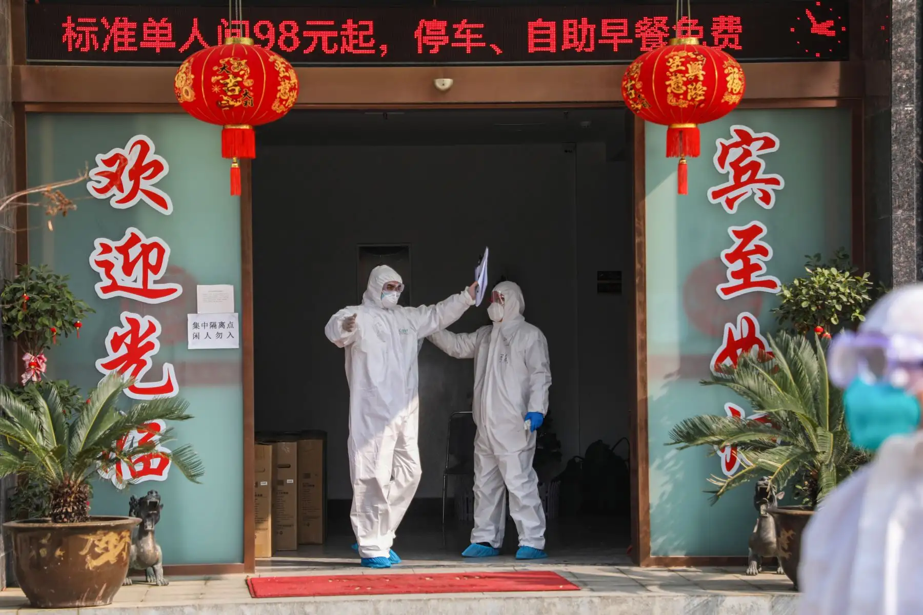 Miembro del personal médico  siendo desinfectado por un colega antes de abandonar una zona de cuarentena convertida de un hotel en Wuhan. AFP
