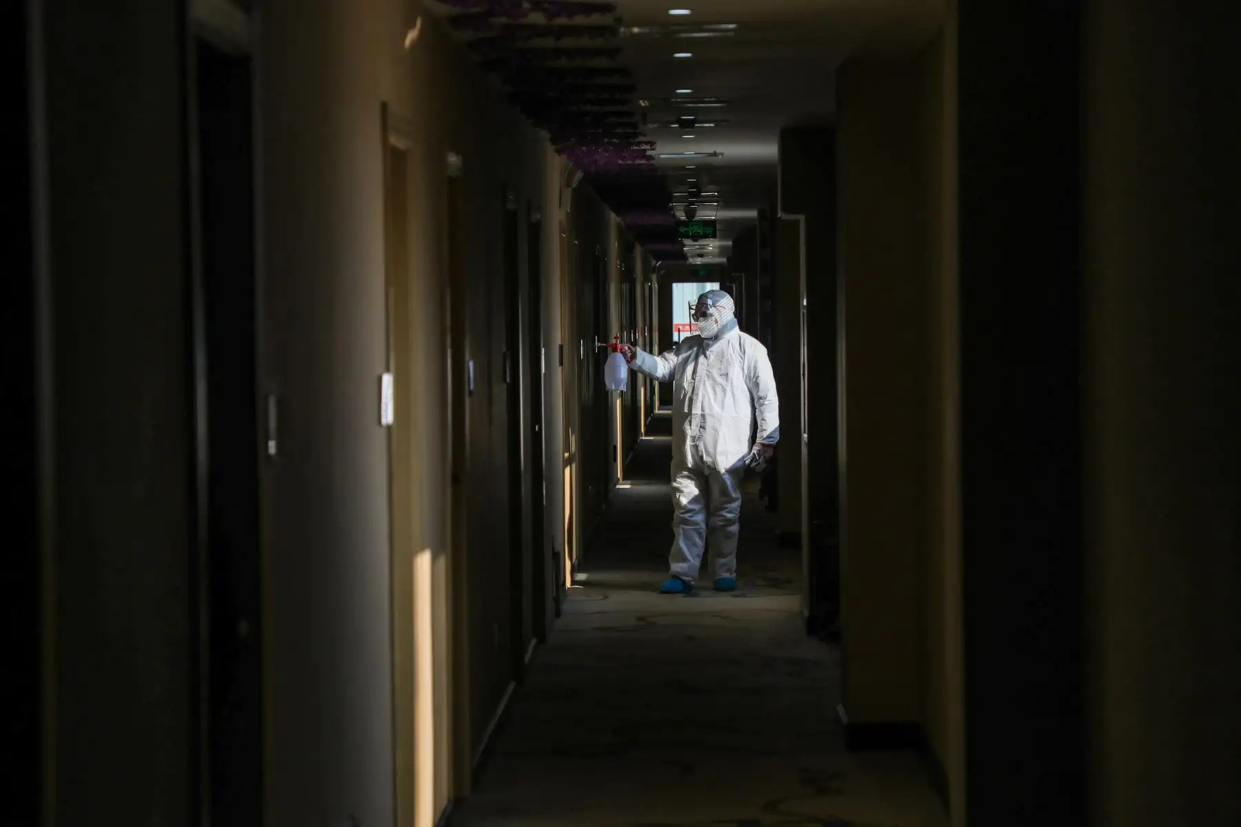 Médico desinfectando en una zona de cuarentena convertida de un hotel en Wuhan. AFP