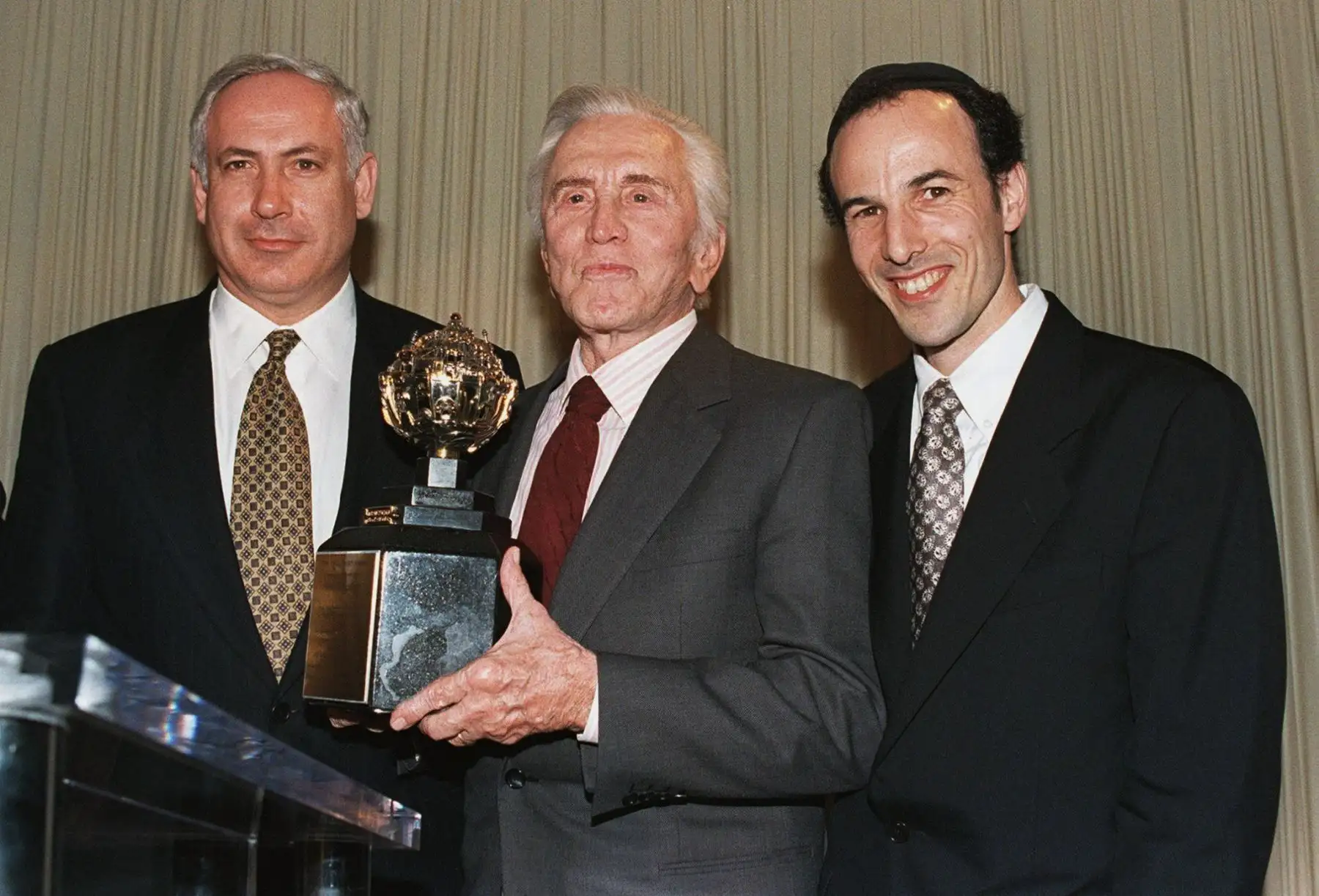 En esta foto de archivo tomada el 17 de noviembre de 1997, el actor estadounidense Kirk Douglas (C) posee el Premio Rey David que le fue entregado por el Fondo de Jerusalén Aish Ha Torah durante una cena en Beverly Hills, a la que asistió el Primer Ministro israelí Benjamin Netanyahu (L) y el rabino Katzow (R).
Foto: AFP