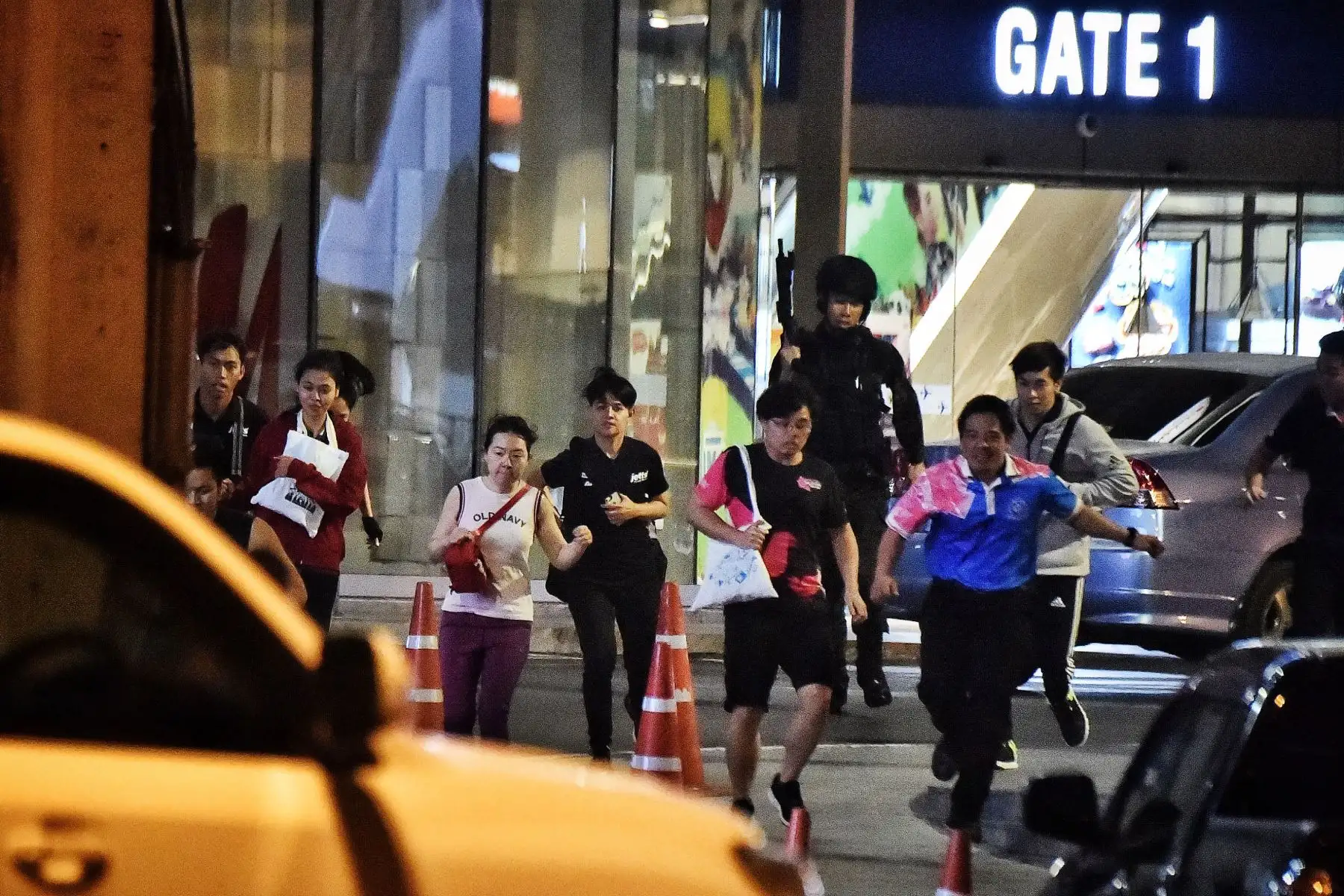 Las personas corren juntas mientras son rescatadas por comandos tailandeses del centro comercial Terminal 21, donde tuvo lugar un tiroteo masivo en el noreste de Tailandia.
Foto: AFP