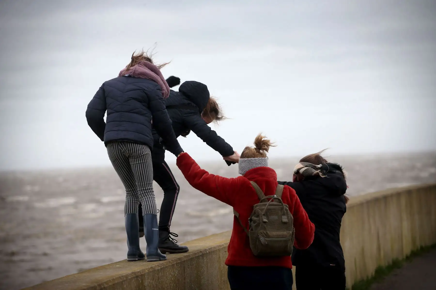 Un grupo de personas intenta caminar contra el fuerte viento durante la tormenta Ciara. Foto: AFP