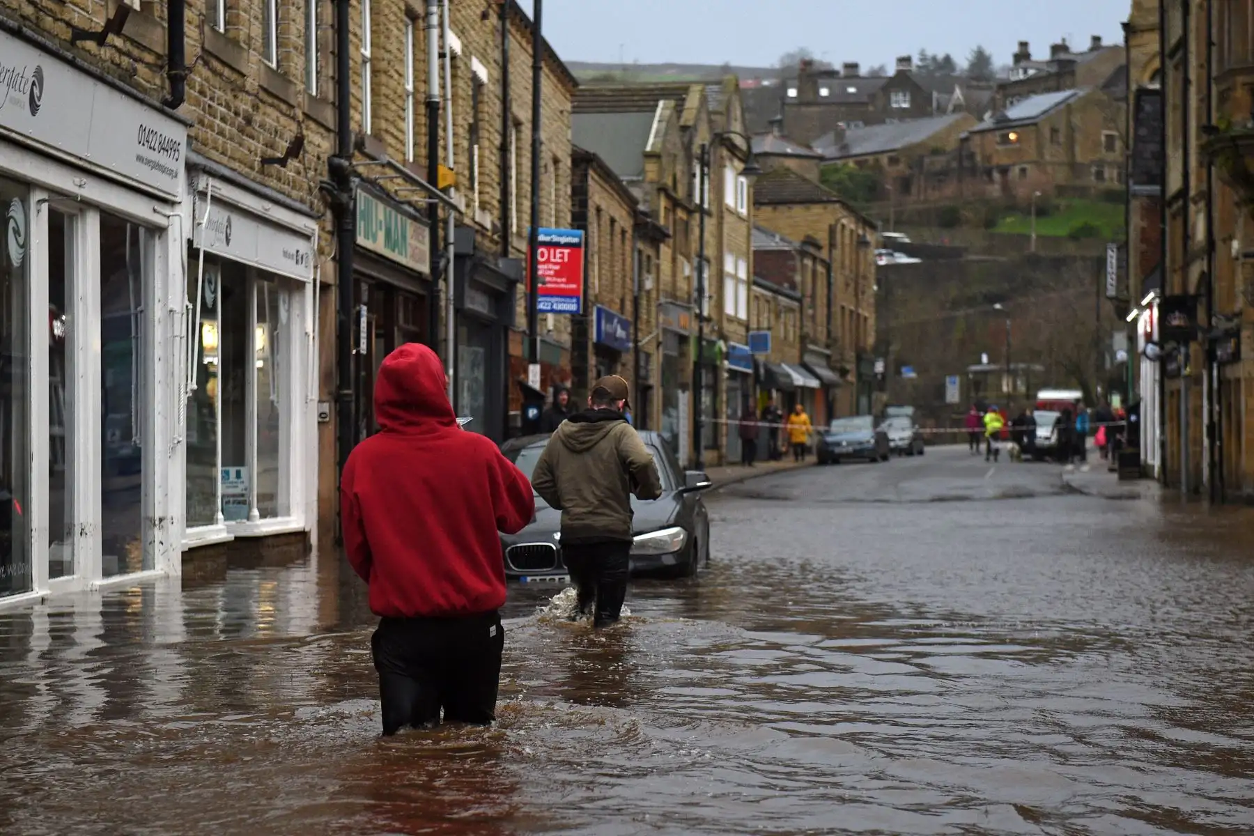 La gente vadea por las inundaciones en las calles de Hebden Bridge, en el norte de Inglaterra, mientras la tormenta Ciara barría el país.
Foto: AFP