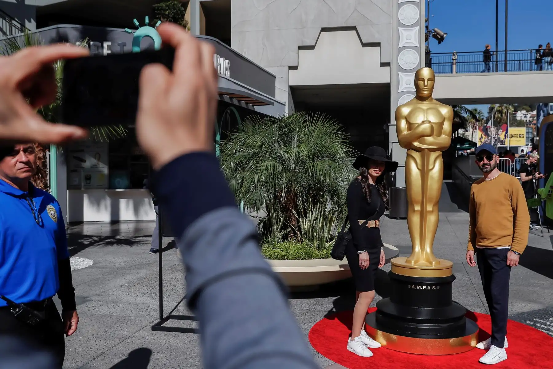 La gente toma fotos junto a la estatua de los Óscar mientras los trabajadores continúan con los preparativos de la alfombra roja para la 92a ceremonia anual de los Premios de la Academia.
Foto: EFE