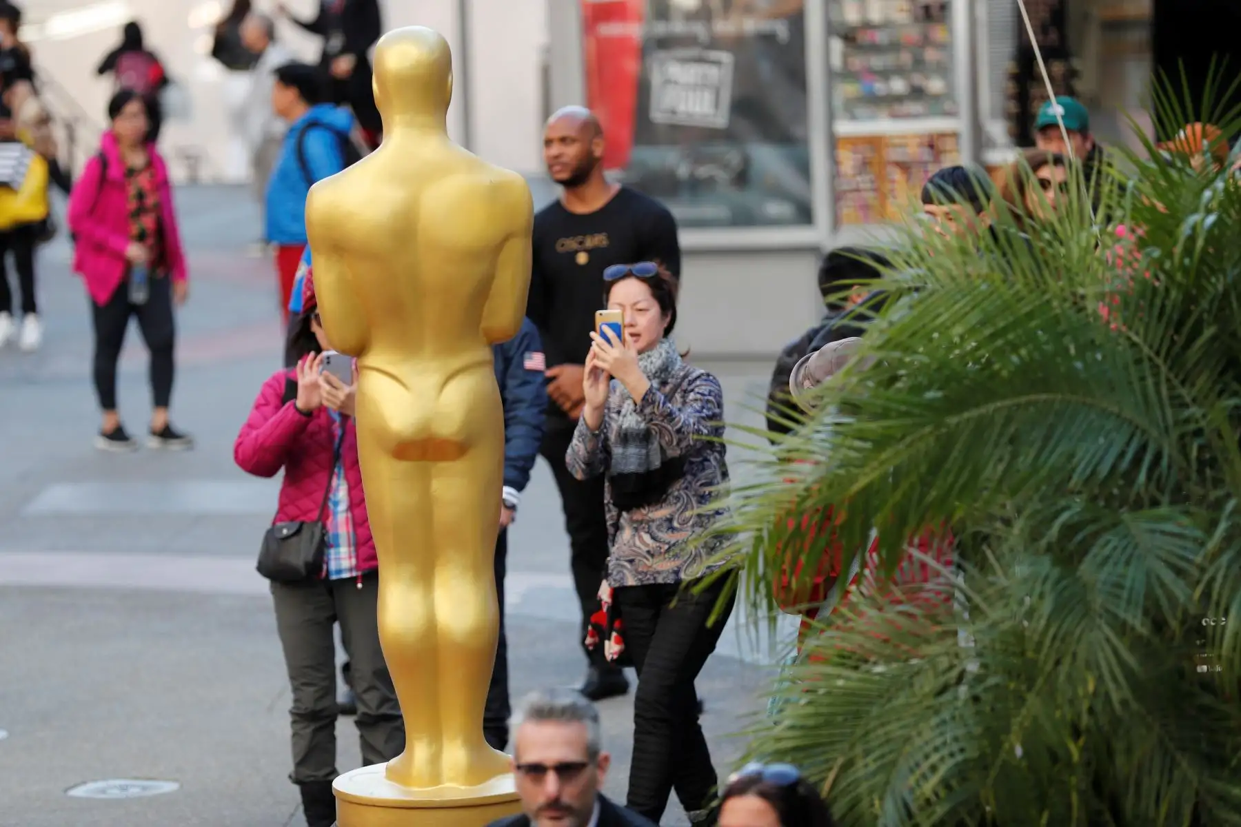 La gente toma fotos junto a la estatua de los Óscar mientras los trabajadores continúan con los preparativos de la alfombra roja para la 92a ceremonia anual de los Premios de la Academia.
Foto: EFE