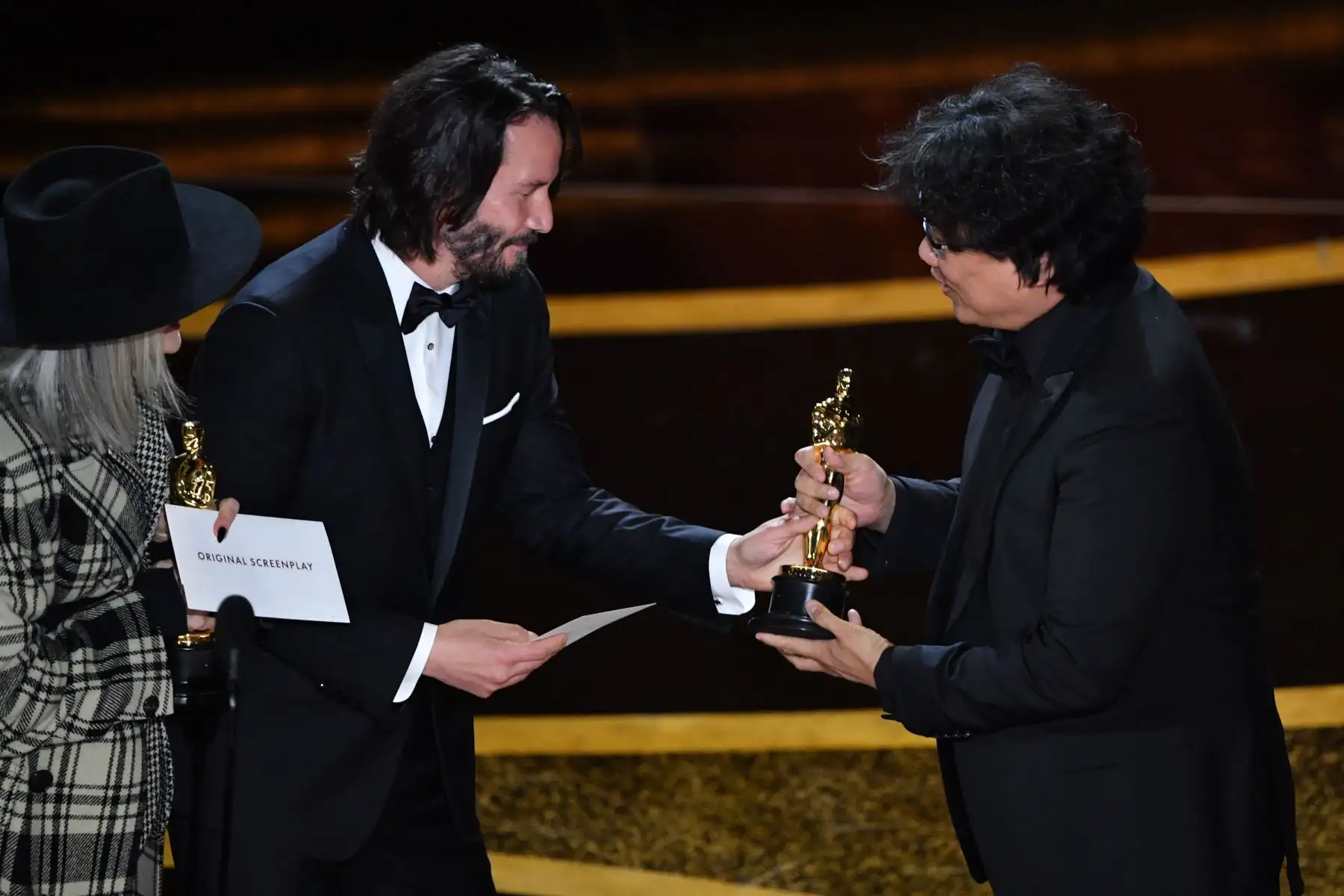 El director de cine surcoreano Bong Joon-ho acepta el premio al Mejor guión original por "Parasite" del actor estadounidense Keanu Reeves  y la actriz estadounidense Diane Keaton durante los 92o Oscars en el Dolby Theatre de Hollywood, California.
Foto: AFP