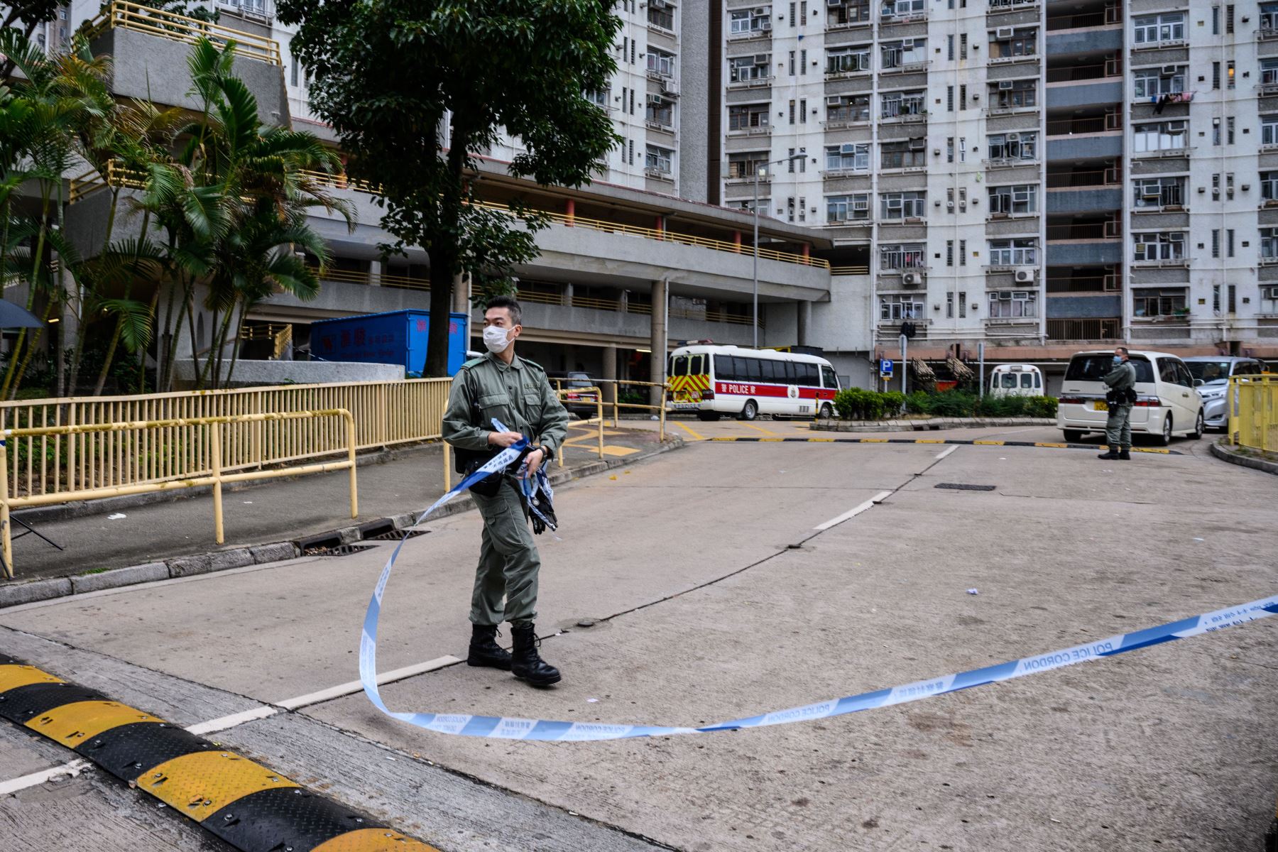 Agentes de policía  hacen guardia frente a un cordón afuera de la Casa Hong Mei en  Hong Kong, luego de evacuar más de 100 personas del bloque de viviendas, donde  cuatro residentes dieron positivo para el nuevo coronavirus. AFP