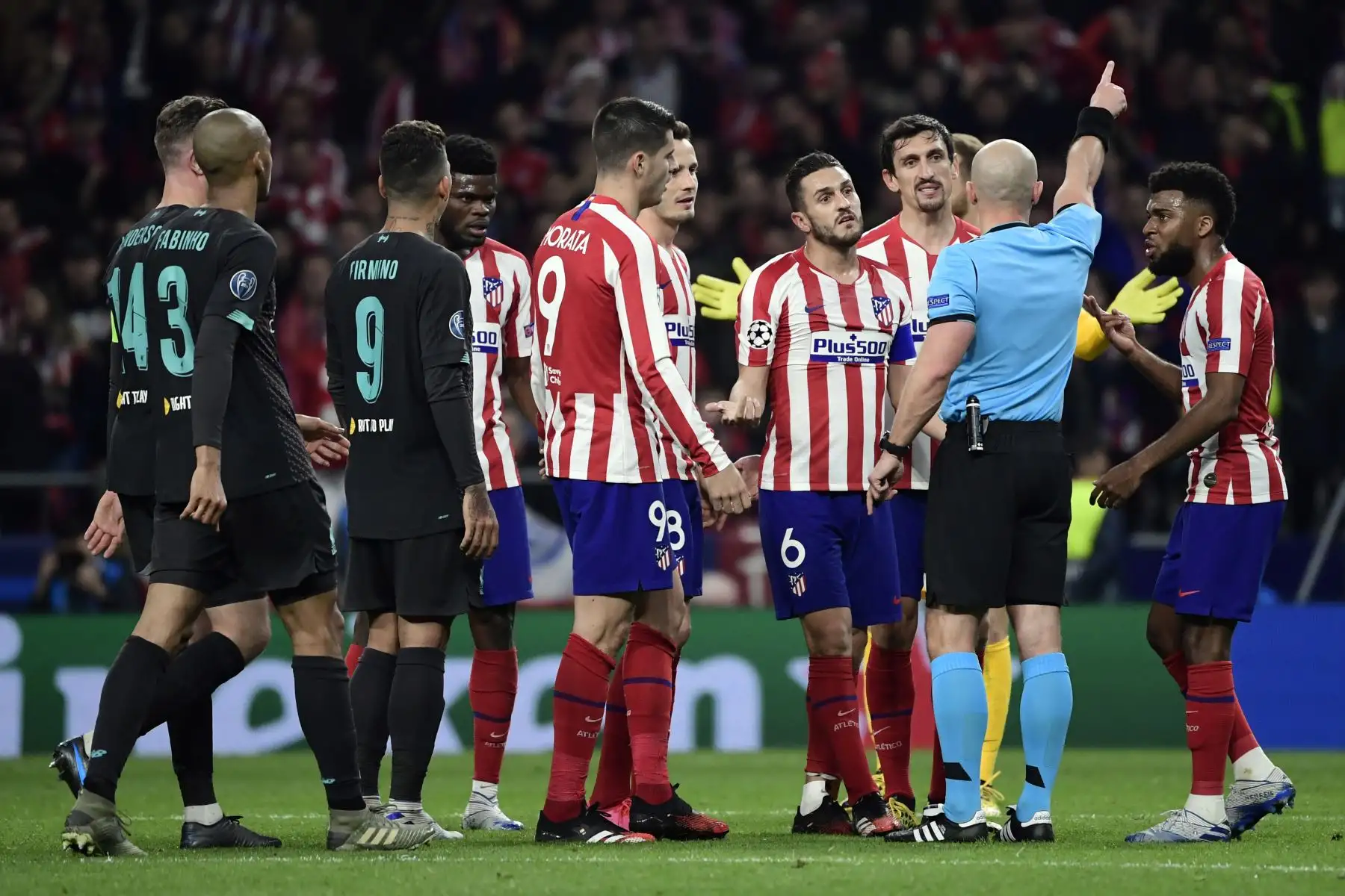 Los jugadores del Atlético de Madrid protestan ante el árbitro polaco Szymon Marciniak durante la UEFA Champions League, octavos de final.Foto:AFP