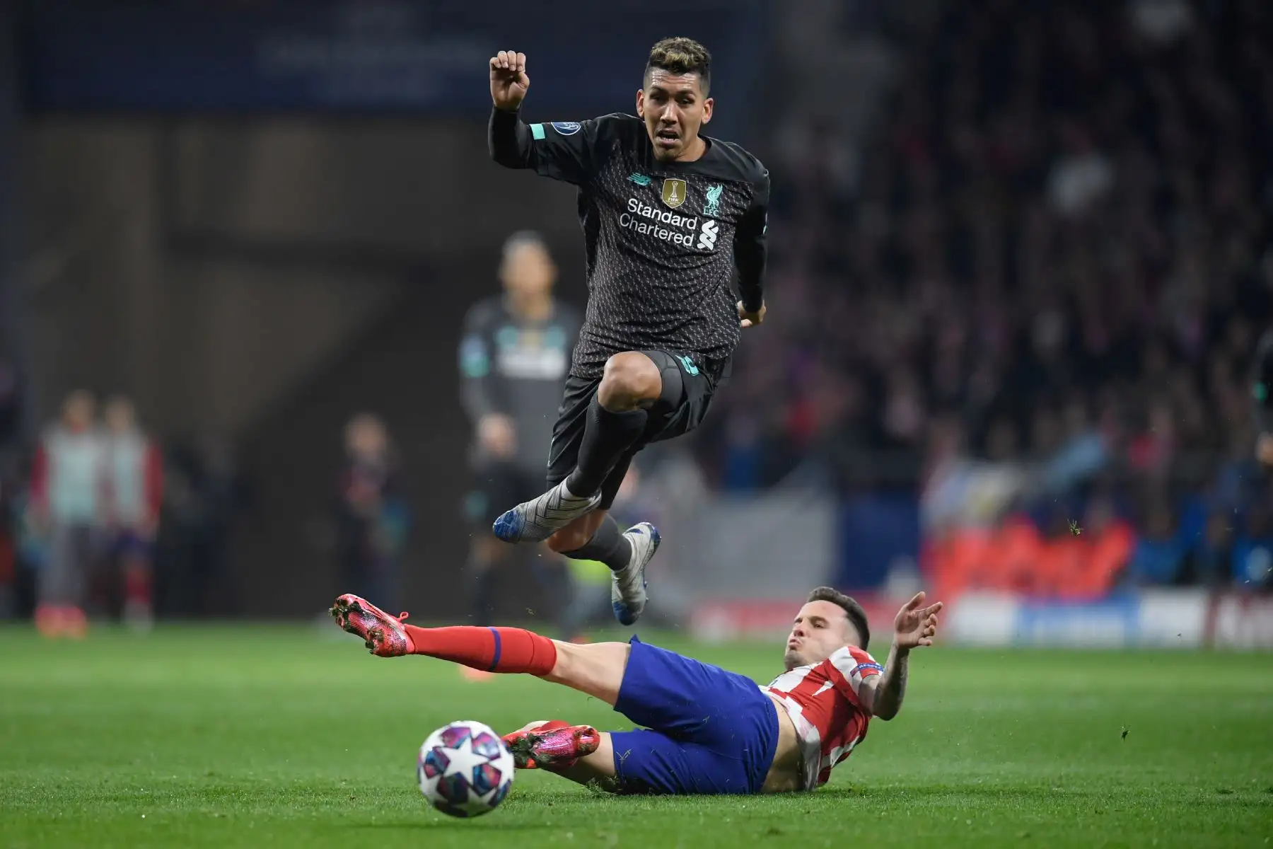 El centrocampista español del Atlético de Madrid Saúl Niguez (abajo) desafía al centrocampista brasileño del Liverpool Roberto Firmino durante la UEFA Champions League, octavos de final.Foto:AFP