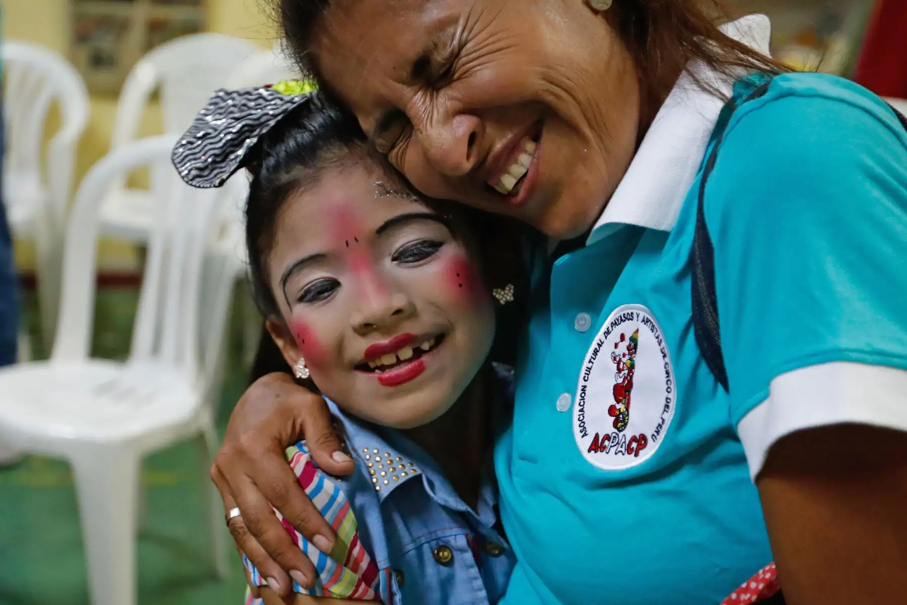 La payasita "Alfiler"de 8 años recibe el abrazo de su madre "Agujita" durante el homenaje a Ricardo Farfán, conocido en el ambiente artístico como el payaso "Pitito" por sus 96 años. Foto: ANDINA/Carlos Lezama