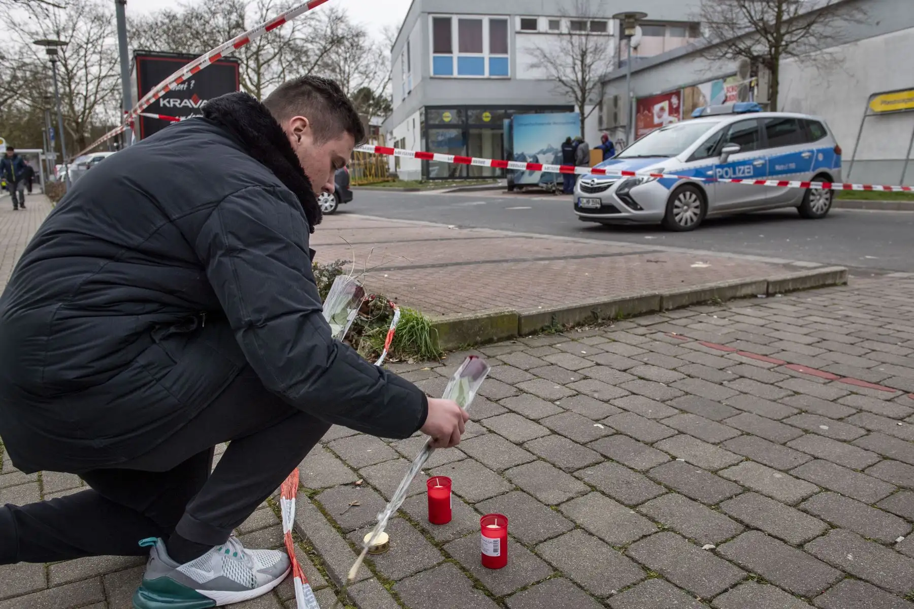 Un hombre pone velas y flores frente a uno de los locales atacados por un tiroteo en Kesselstadt, cerca de Frankfurt, Alemania occidental. Foto: AFP
