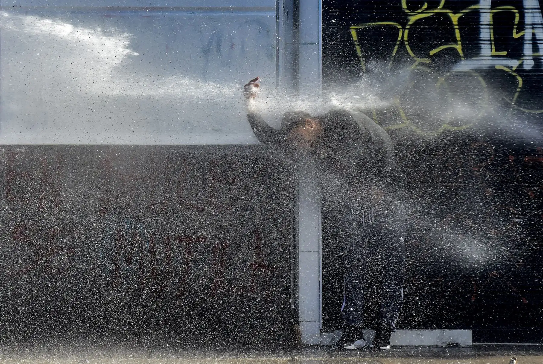 Un cañón de agua de la policía rocía a un manifestante durante una protesta contra el gobierno del presidente chileno Sebastián Piñera en Viña del Mar, durante el Festival de Música de Viña del Mar. AFP