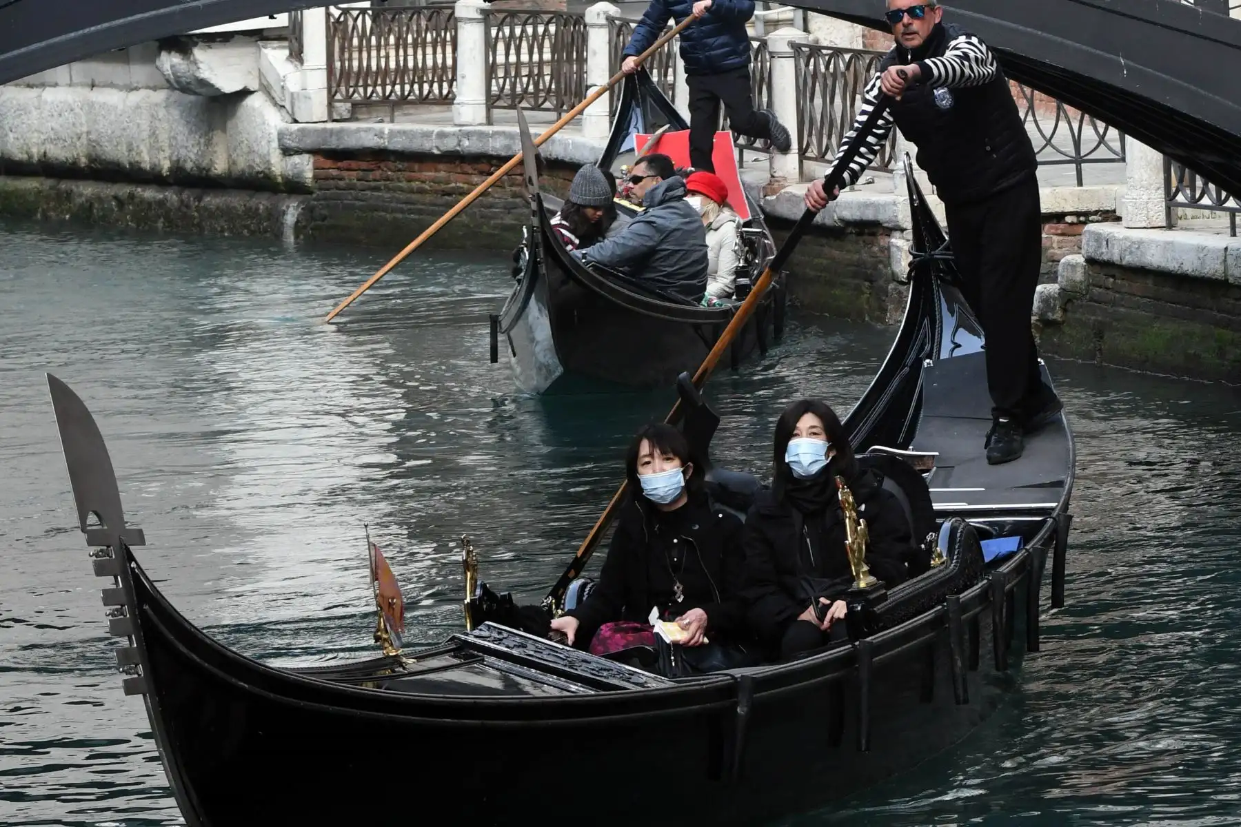 Turistas asiáticos que llevan máscaras protectoras viajan en una góndola en Venecia después de que el carnaval se canceló debido a un brote de coronavirus en Italia. Foto: AFP