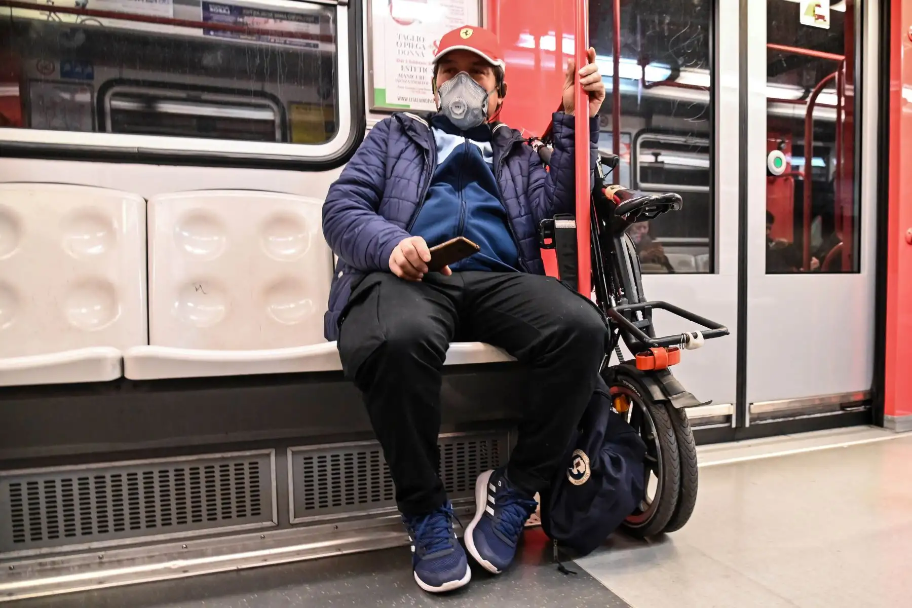 Un hombre que llevaba una máscara protectora se sienta en el metro, en el centro de Milán. Foto: AFP