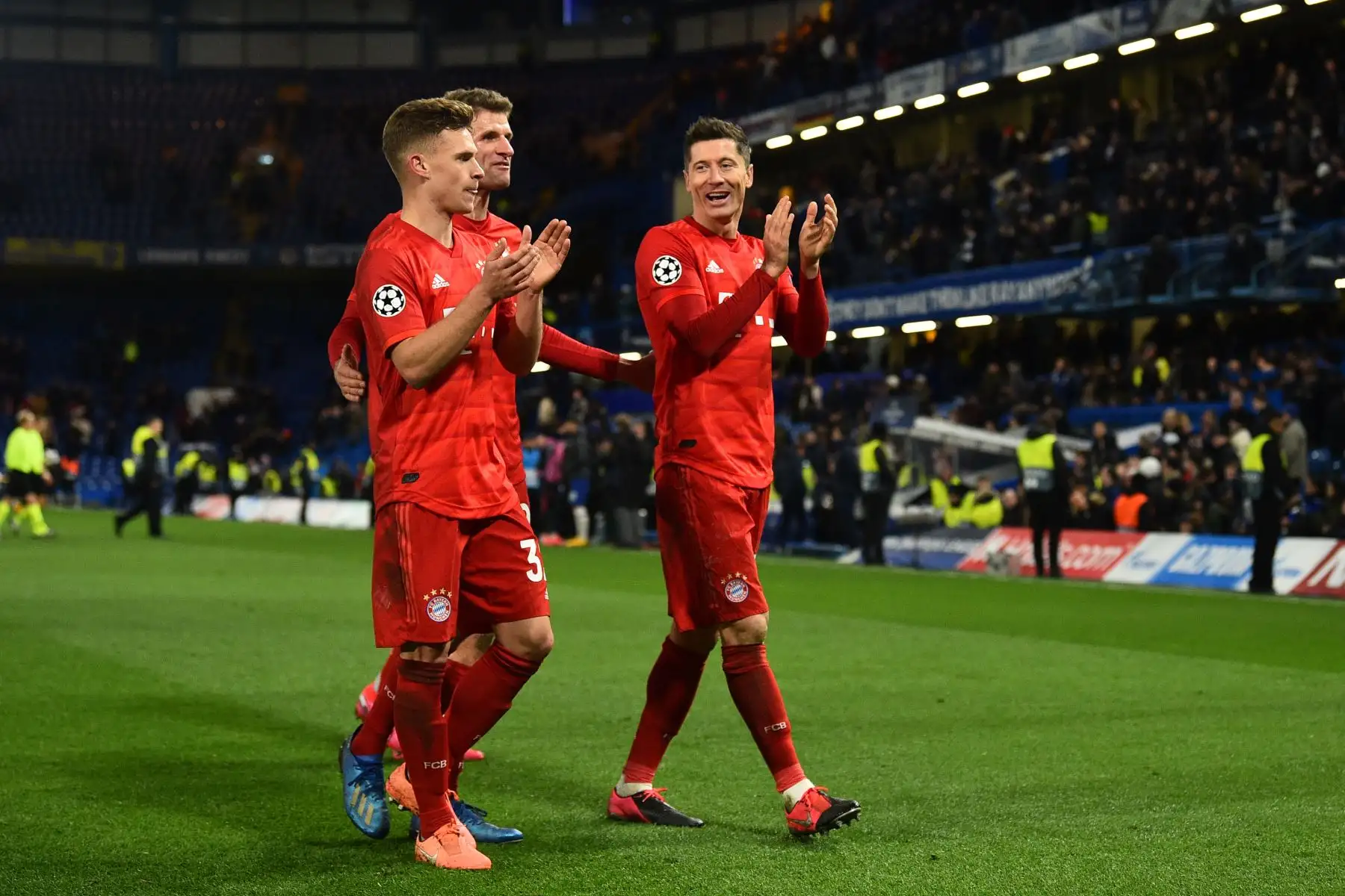 El centrocampista alemán del Bayern Múnich Joshua Kimmich (L), el delantero alemán del Bayern Múnich Thomas Mueller (C) y el delantero polaco del Bayern Múnich Robert Lewandowski (R) celebran su victoria con sus seguidores después de la ronda de la Liga de Campeones de la UEFA. Foto:AFP