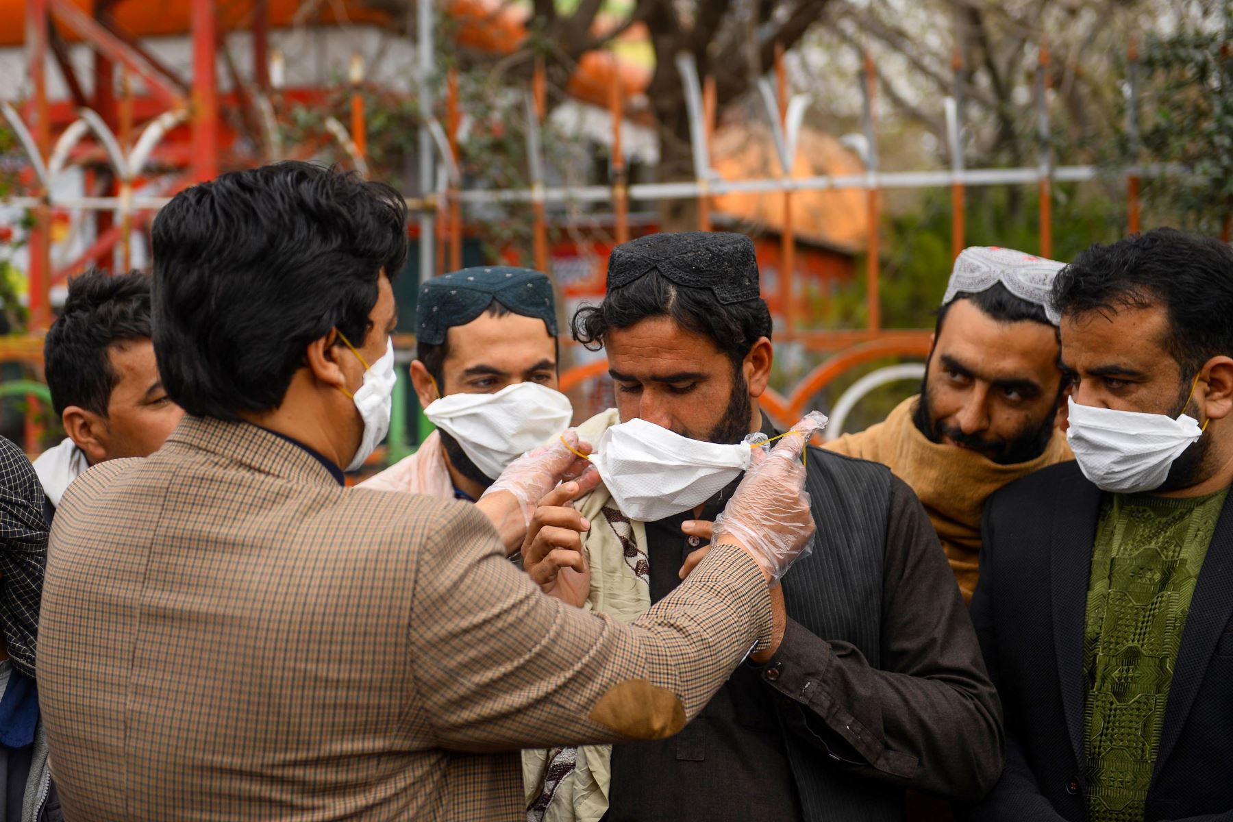 Un voluntario entrega máscaras faciales gratuitas a las personas como medida preventiva contra la propagación del coronavirus COVID-19, en la ciudad de Herat en Pakistán. Foto: AFP