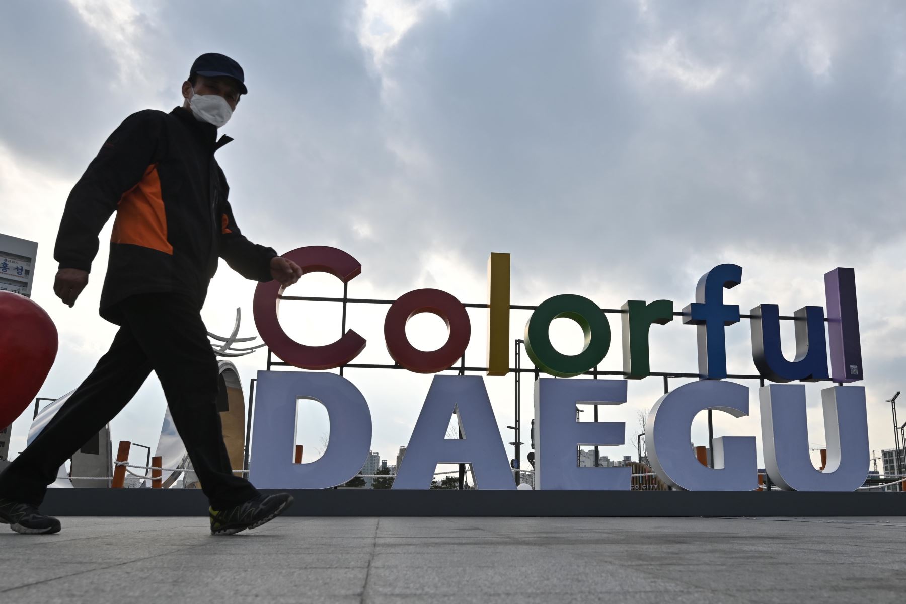 Un hombre lleva una máscara facial protectora, como medida preventiva contra el coronavirus COVID-19, camina cerca de la estación de ferrocarril de Dongdaegu. Foto: AFP