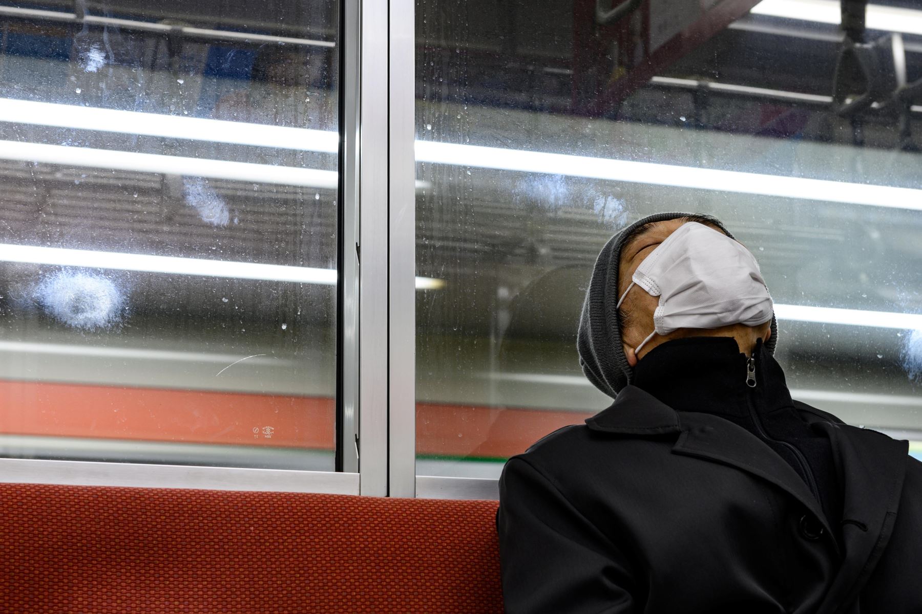 Un hombre con una máscara facial, viaja en un tren subterráneo en Tokio. Foto: AFP