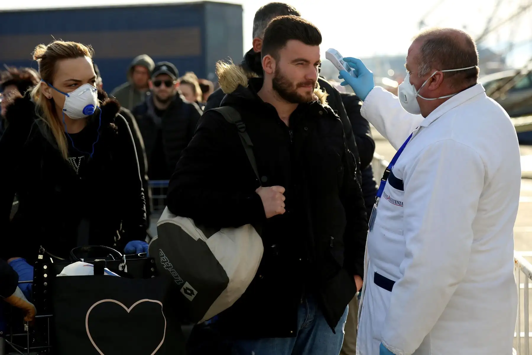 Personal médico revisa a los pasajeros entrantes que vienen de Italia para detectar cualquier posible síntoma de Covid-19, también conocido como Coronavirus, en la principal ciudad portuaria de Durres, Albania. Foto: AFP
