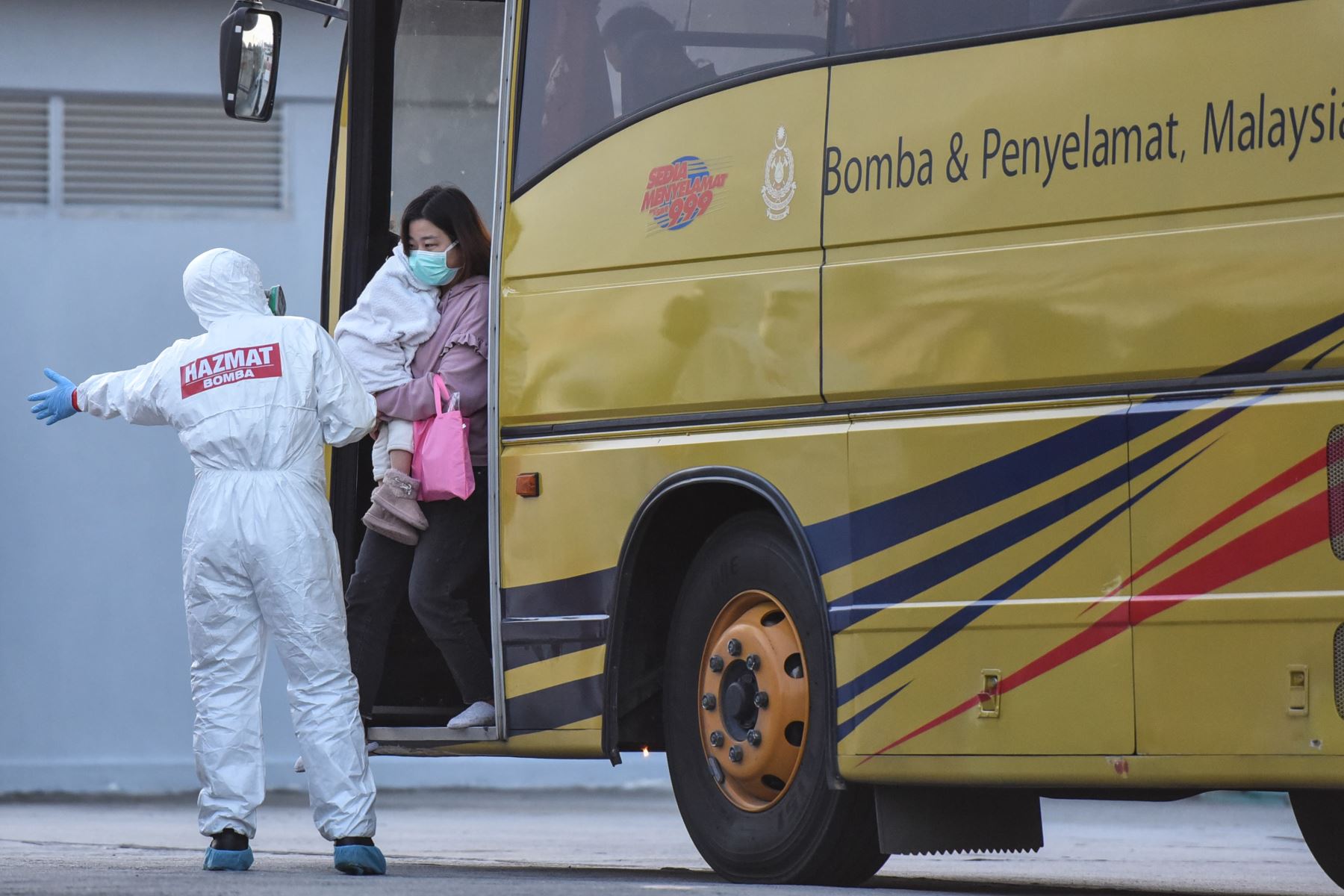 Ciudadanos de Malasia, evacuados de la ciudad china de Wuhan, el epicentro del nuevo brote de coronavirus COVID-19, son dirigidos desde un autobús  cuando llegan al aeropuerto internacional de Kuala Lumpur. Foto: AFP