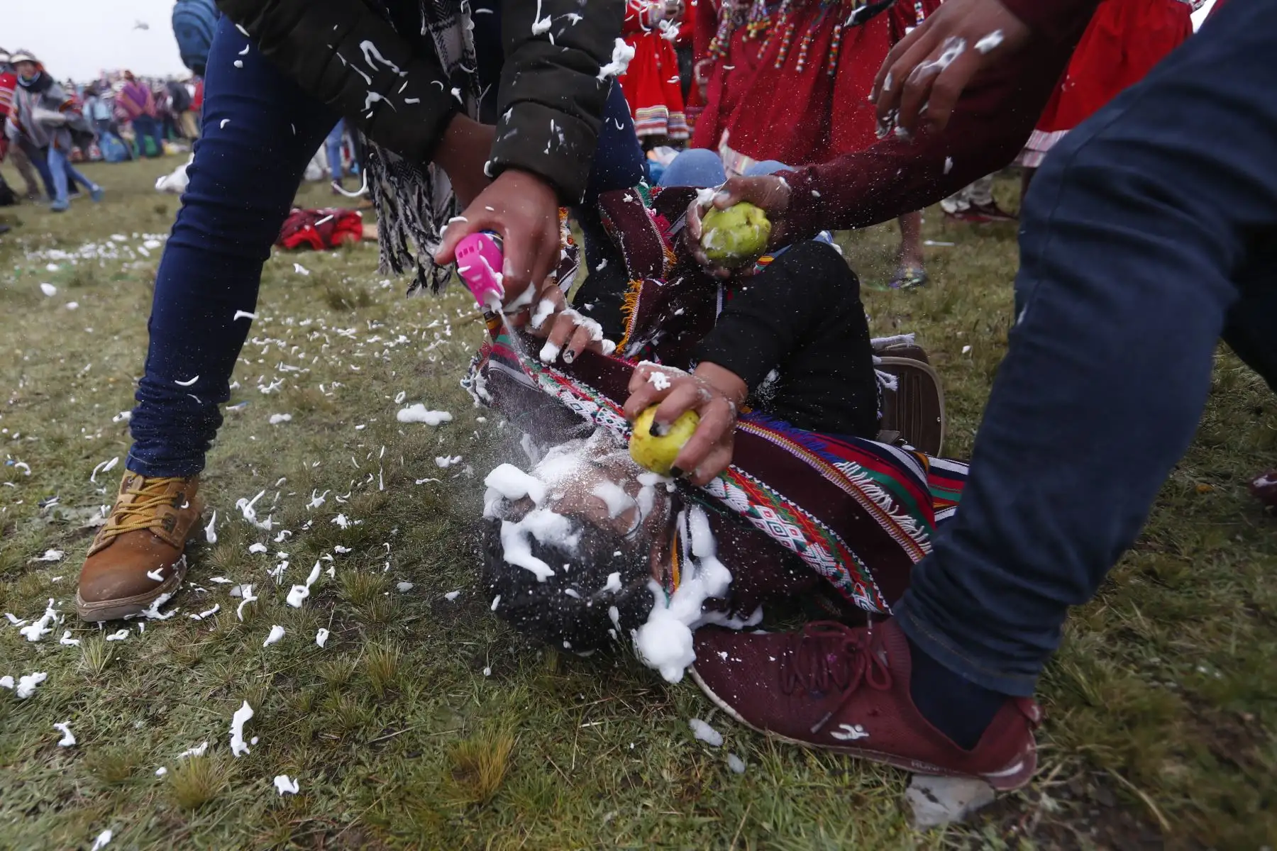 Dos jóvenes logran tumbar a una alegre muchacha quien venía lanzando espuma a diestra y siniestra contra ellos. Foto: ANDINA/Renato Pajuelo