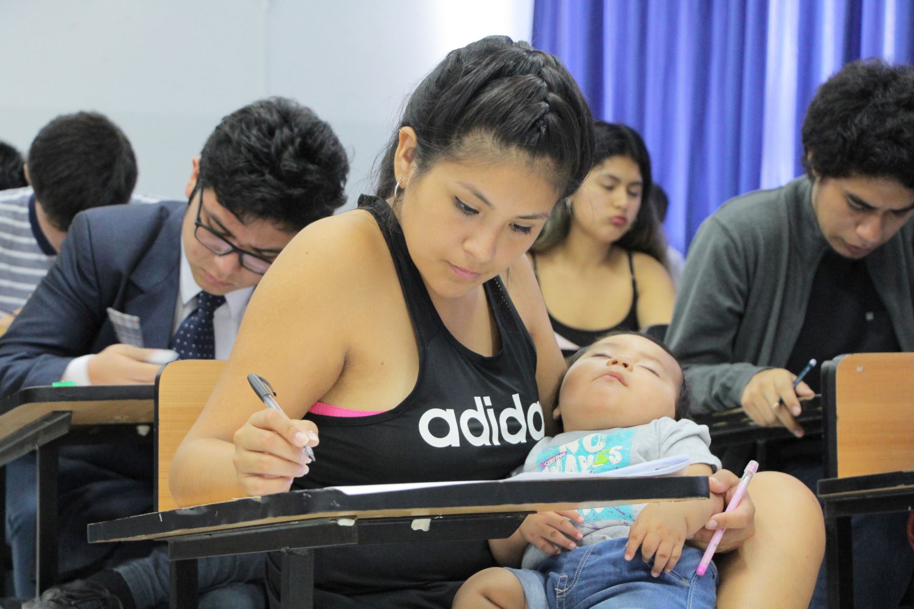 Postulante rinde examen de admisión a universidad con su bebé en brazos. Foto: Andina/Difusión.