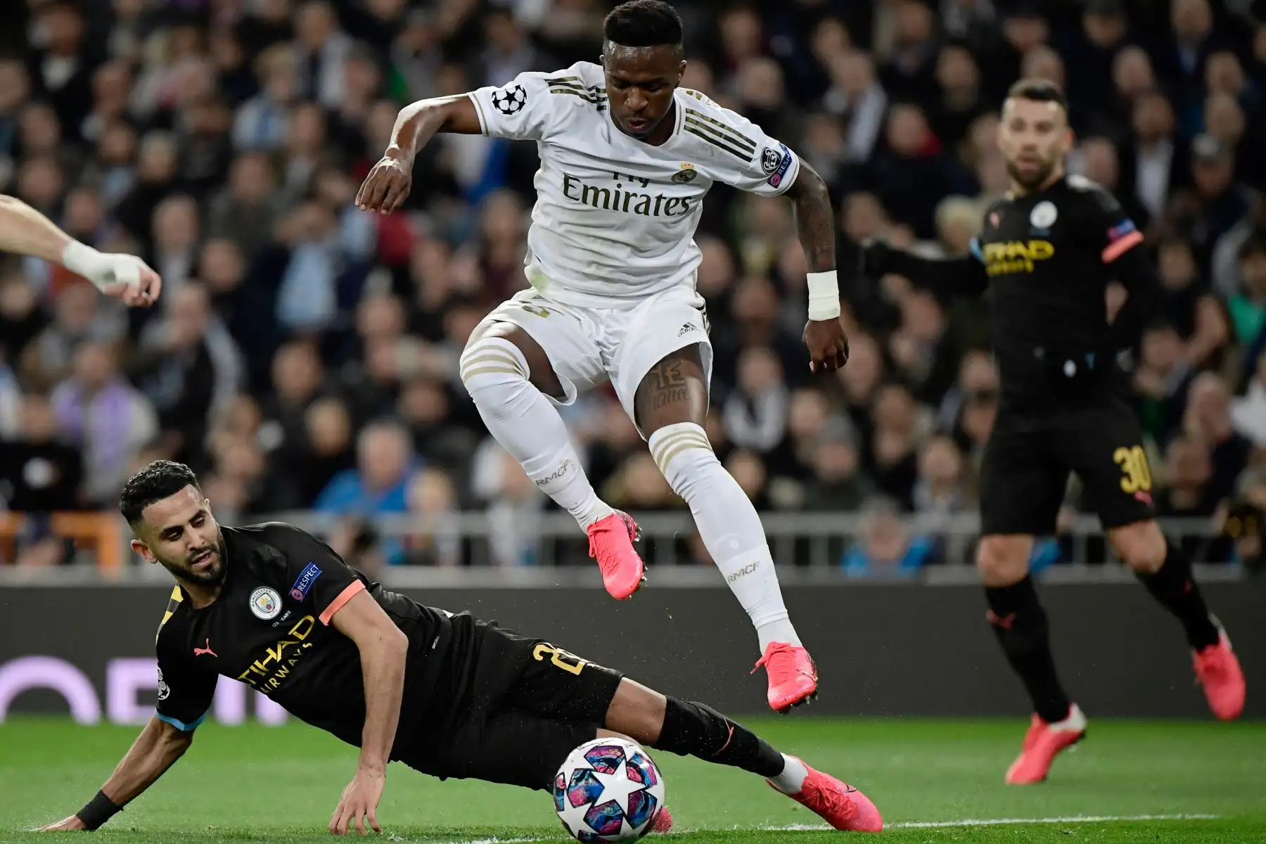 El delantero brasileño del Real Madrid, Vinicius Junior, salta sobre el centrocampista argelino del Manchester City, Riyad Mahrez, durante la ronda de 16 de la UEFA Champions League entre el Real Madrid CF y el Manchester City.
Foto: AFP