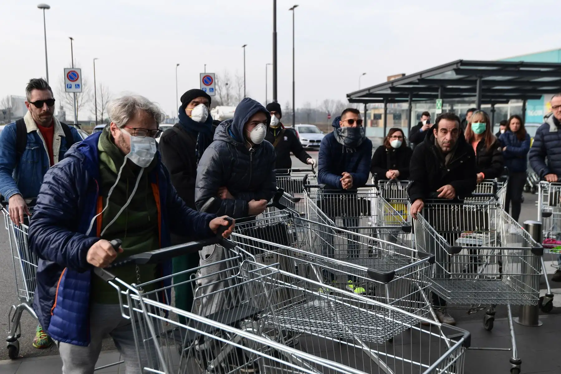 Los residentes esperan tener acceso a comprar en un supermercado en pequeños grupos de cuarenta personas  en la  ciudad italiana de Casalpusterlengo, a la sombra de un nuevo brote de coronavirus, mientras Italia tomó medidas drásticas de contención a medida que el mundo teme por el epidemia en espiral. AFP