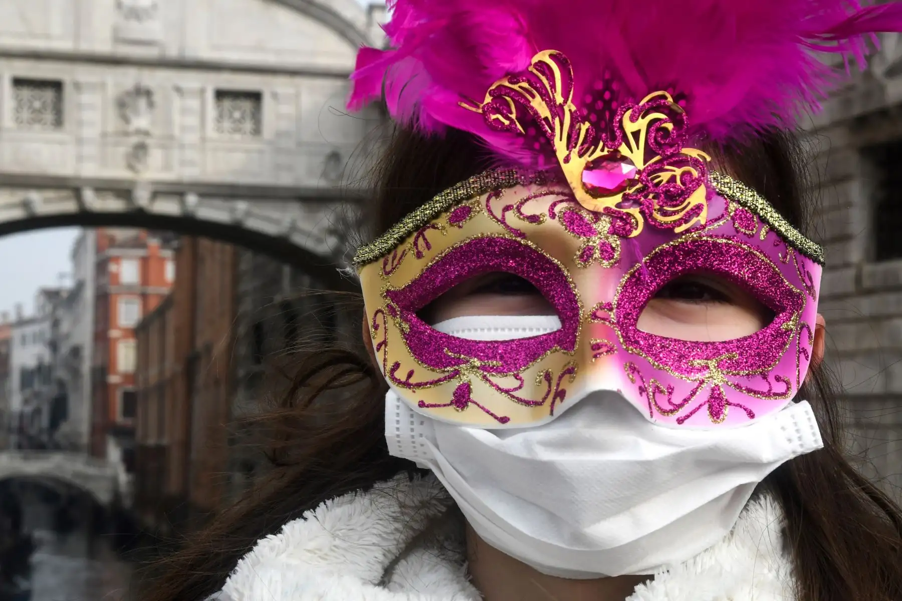 Un joven turista con una máscara protectora y una máscara de Carnaval visita las calles de Venecia. AFP