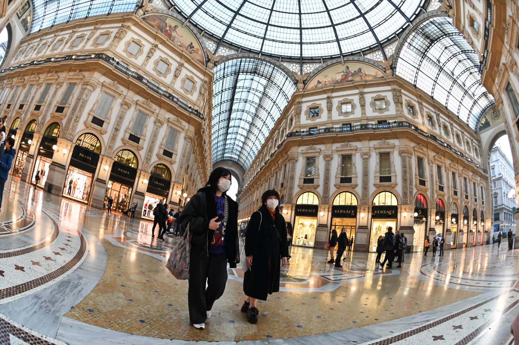 Las personas que llevan máscaras protectoras visitan la Galería Vittorio Emanuele II, en el centro de Milán, luego de tomar medidas de seguridad en el norte de Italia contra el COVID-19. AFP