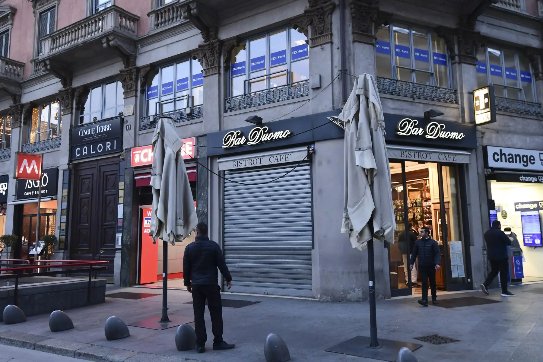 Un hombre se para frente a un bar al lado de la Piazza del Duomo en el centro de Milán que cierra a las 6 p.m. luego de tomar medidas de seguridad en el norte de Italia contra el COVID-19. AFP