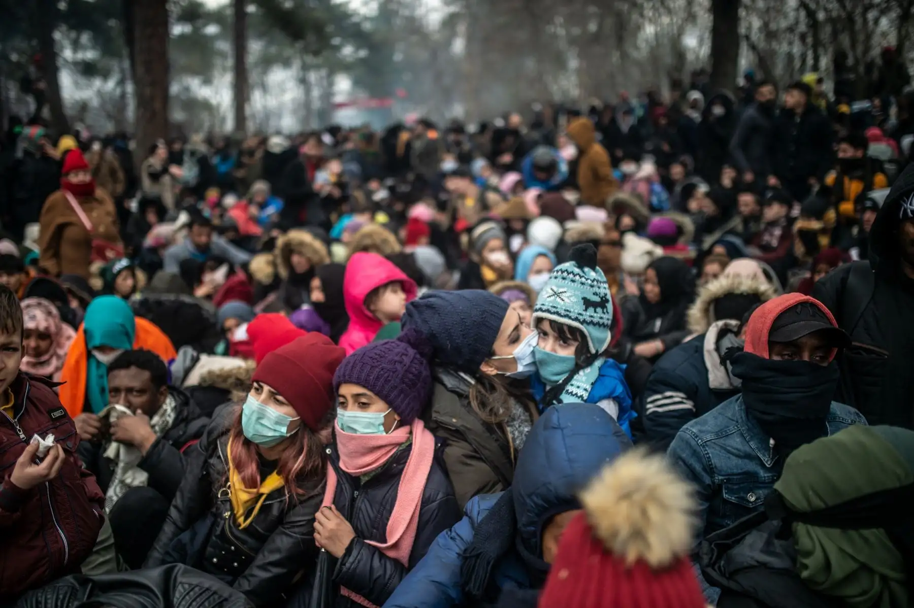 Los migrantes con máscaras protectoras esperan en la zona de amortiguamiento en la frontera entre Turquía y Grecia en Pazarkule, en el distrito de Edirne.
Foto: AFP