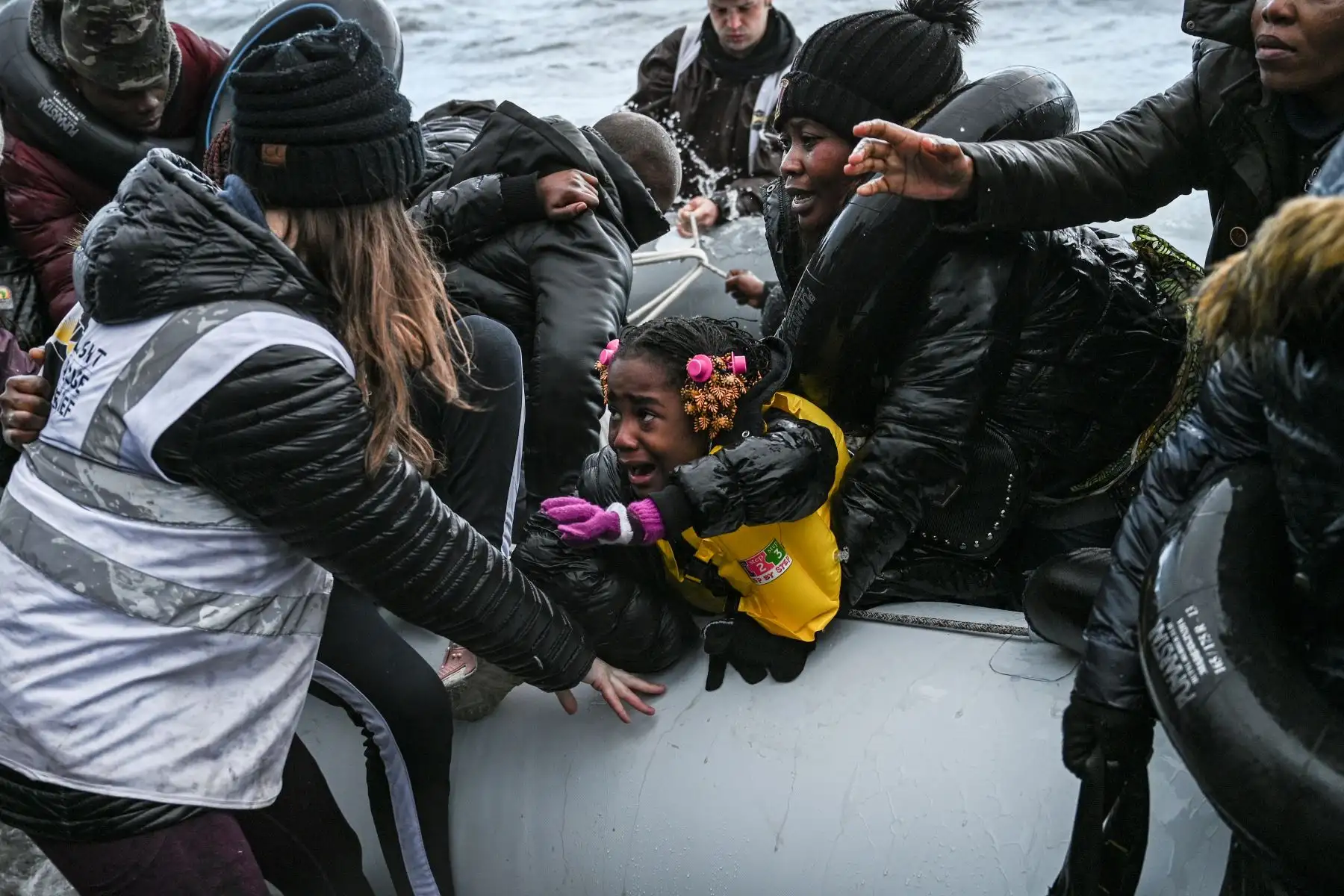 Miembro de una ONG ayuda a una niña de bote que  transportaba a 27 refugiados y migrantes procedentes de Gambia y la República del Congo a tierras en la isla de Lesbos después de ser rescatados por un barco de guerra durante su cruce marítimo entre Turquía y Grecia Foto: AFP