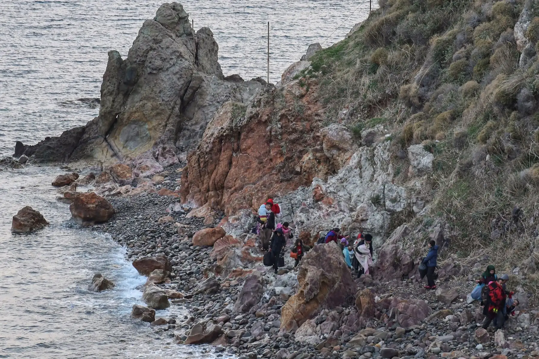 Los migrantes caminan en una playa cerca de Skala Sykamineas en la isla griega de Lesbos después de cruzar el mar Egeo entre Turquía y Grecia. Foto: AFP