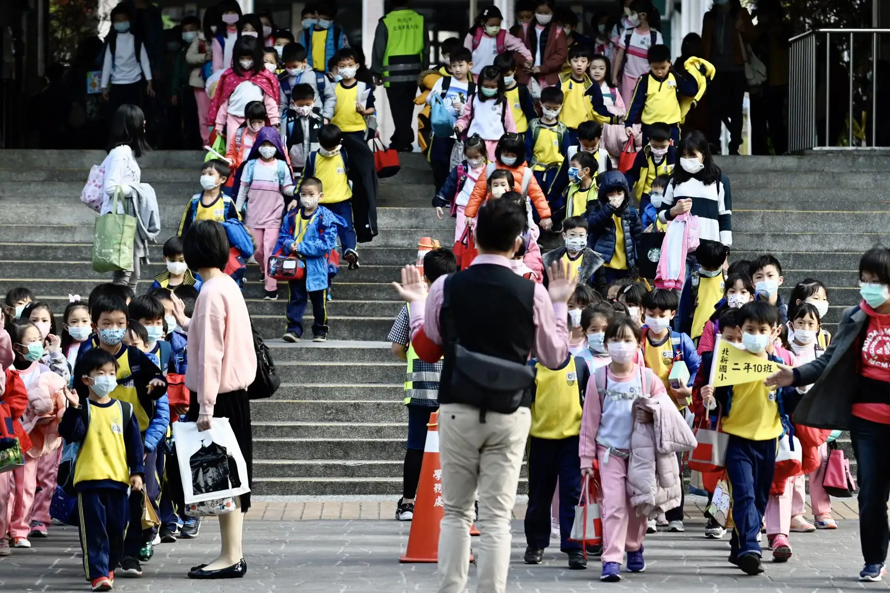 Los niños que llevan máscaras faciales abandonan su escuela primaria al final del día en el distrito de Xindian, Nueva Ciudad de Taipei. Foto: AFP